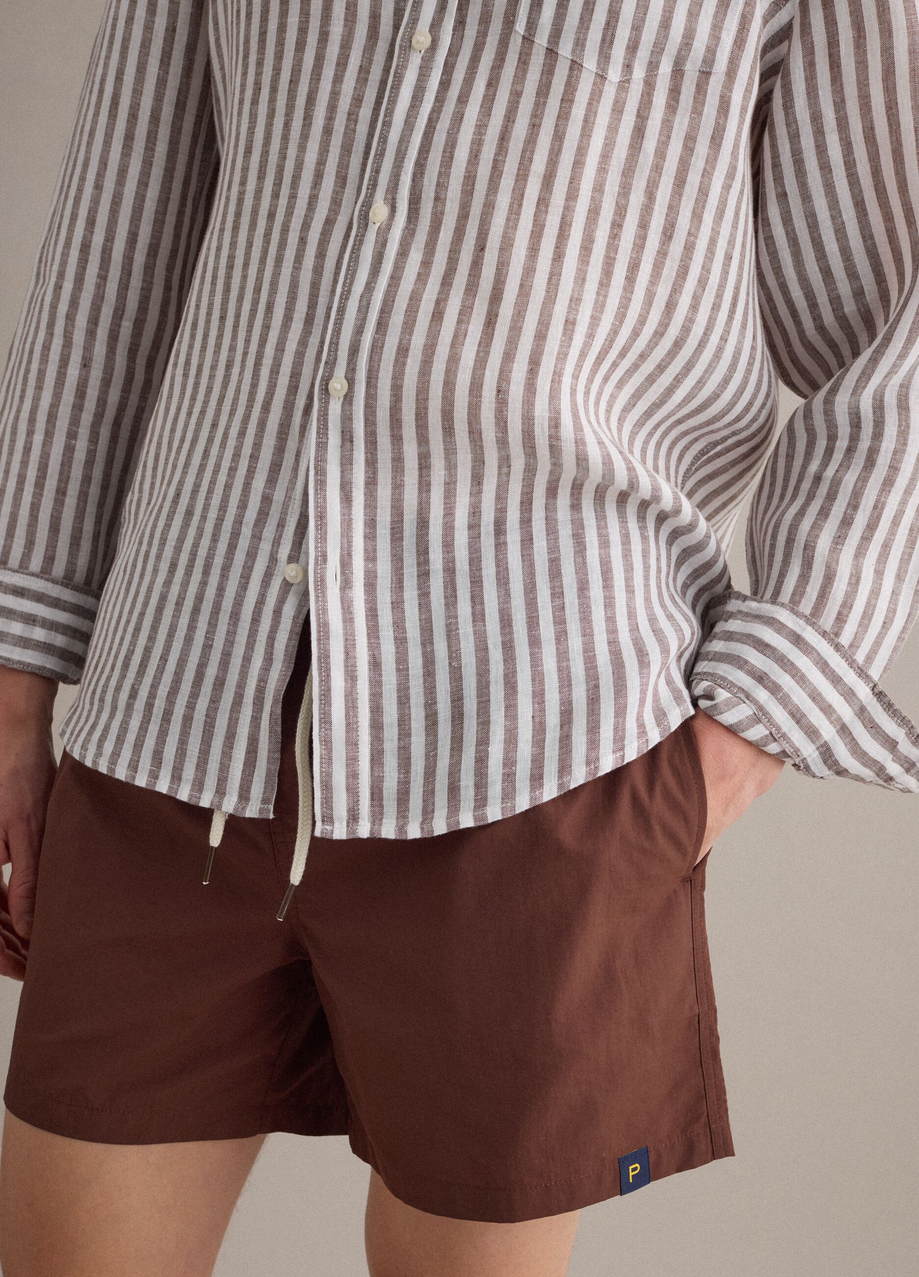 Brown swim shorts with elasticated waistband and drawstring