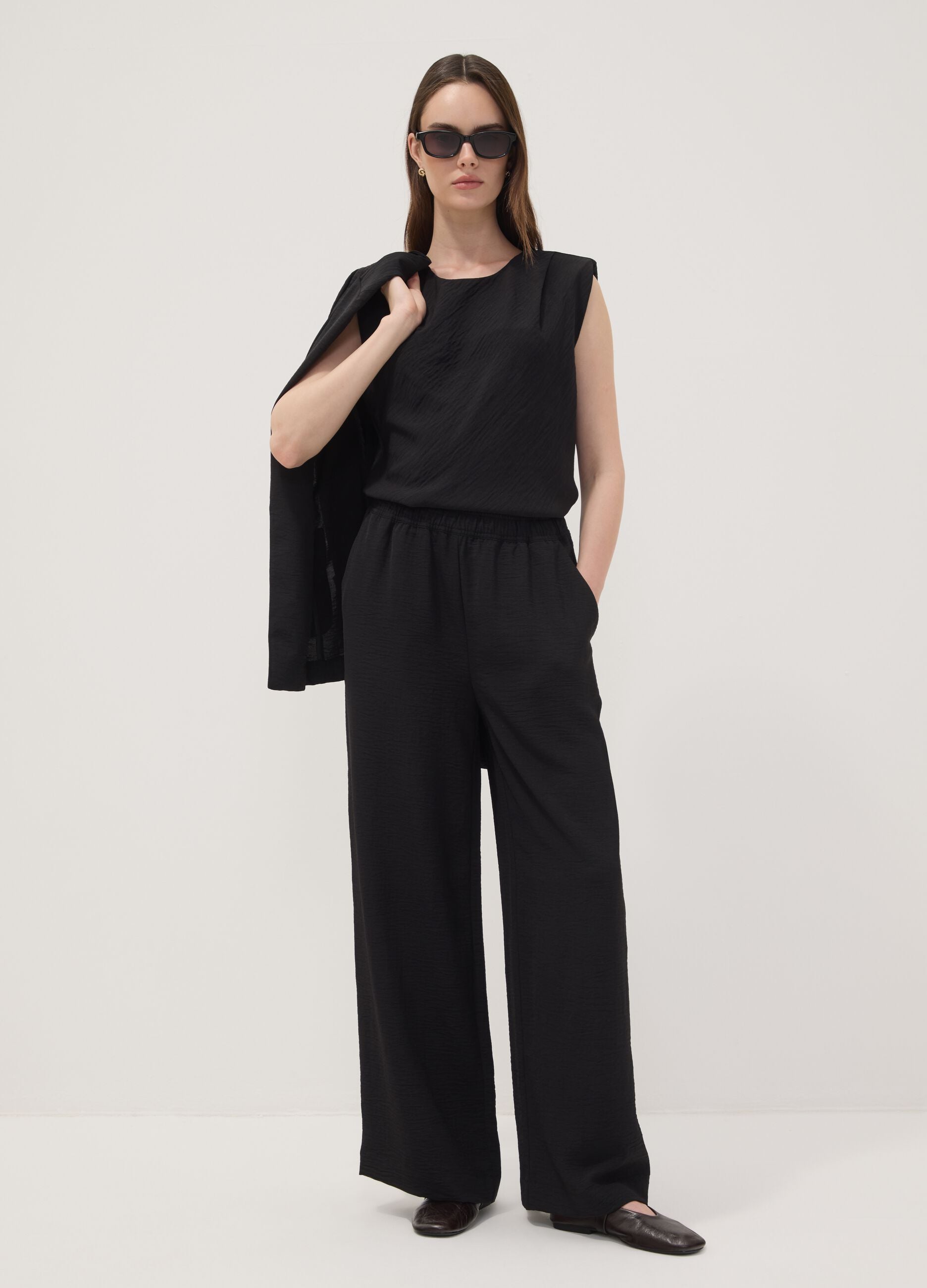 Blusa nera smanicata con texture pliss&eacute; regular fit