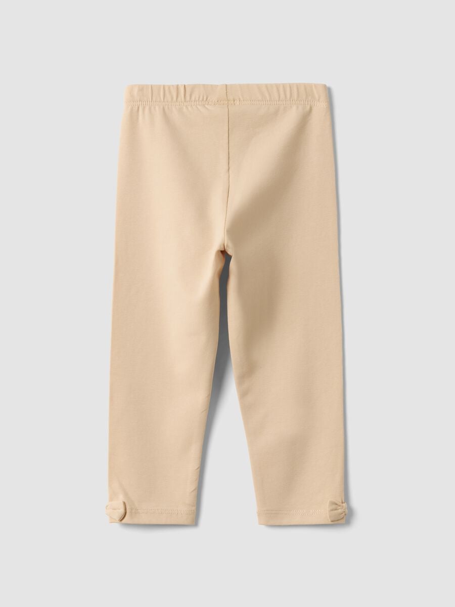 Leggings beige in cotone organico elasticizzato con fiocchi per bimba_1