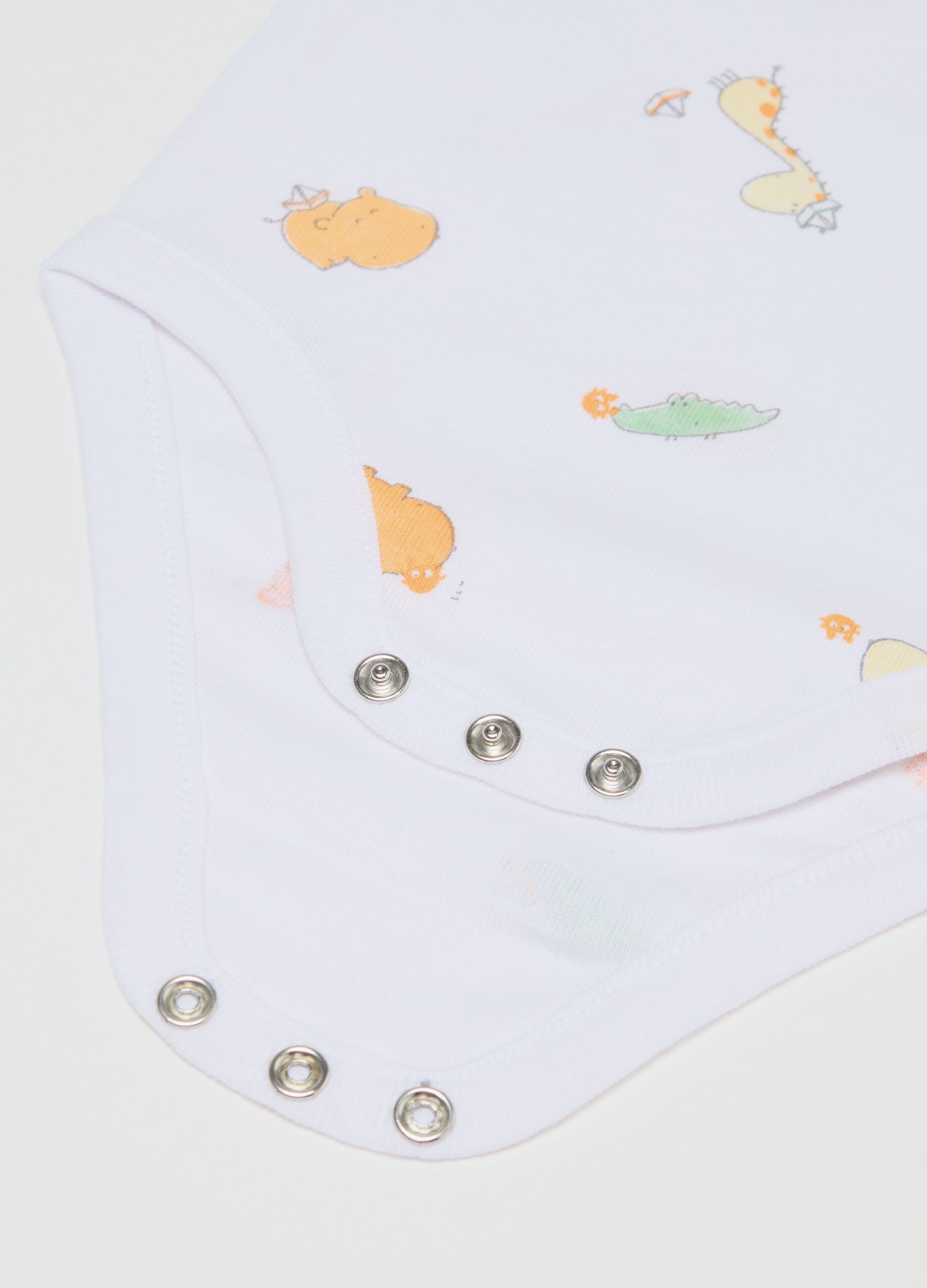 Three-pack white and green sleeveless bodysuits in organic cotton with print
