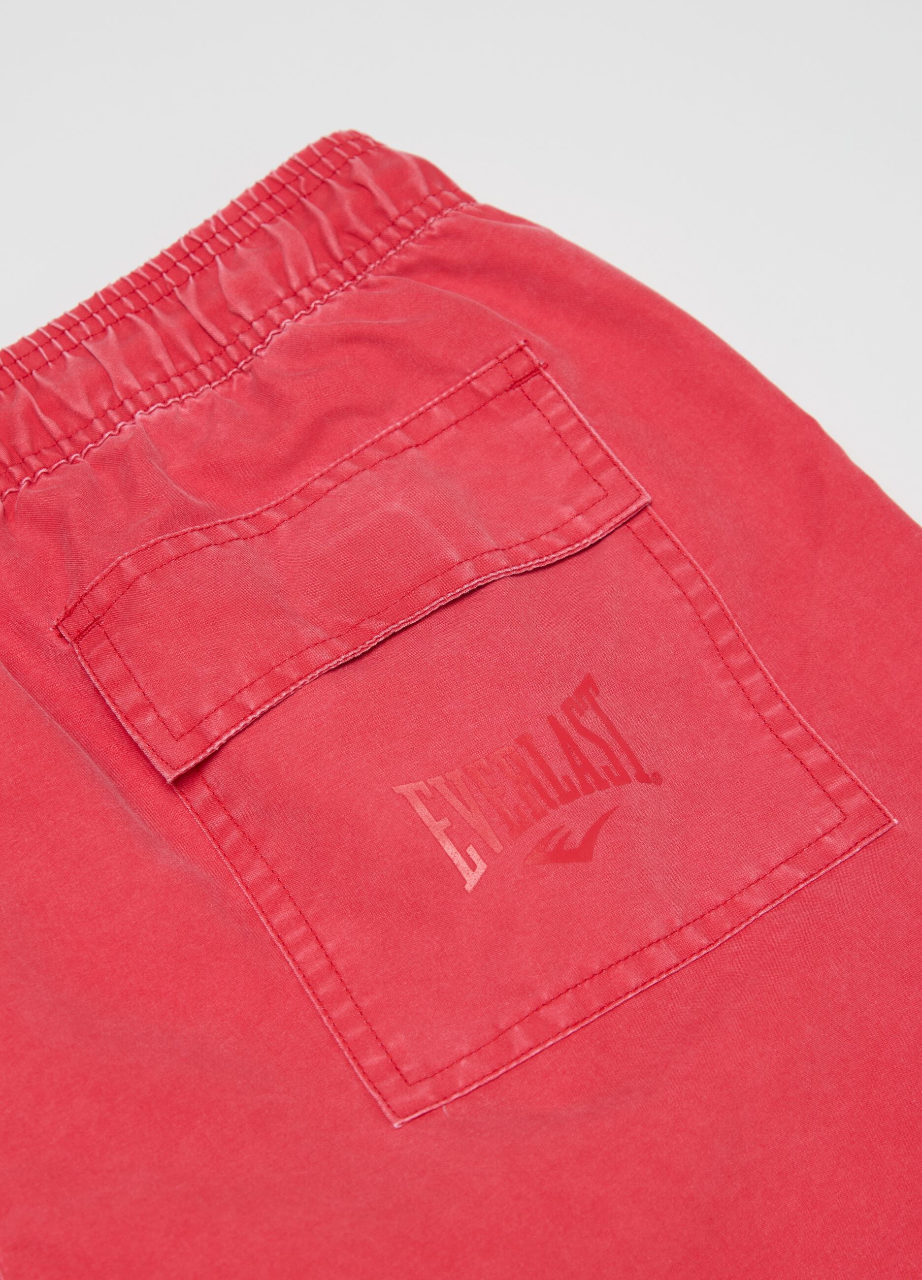 Red swimming trunks with logo print