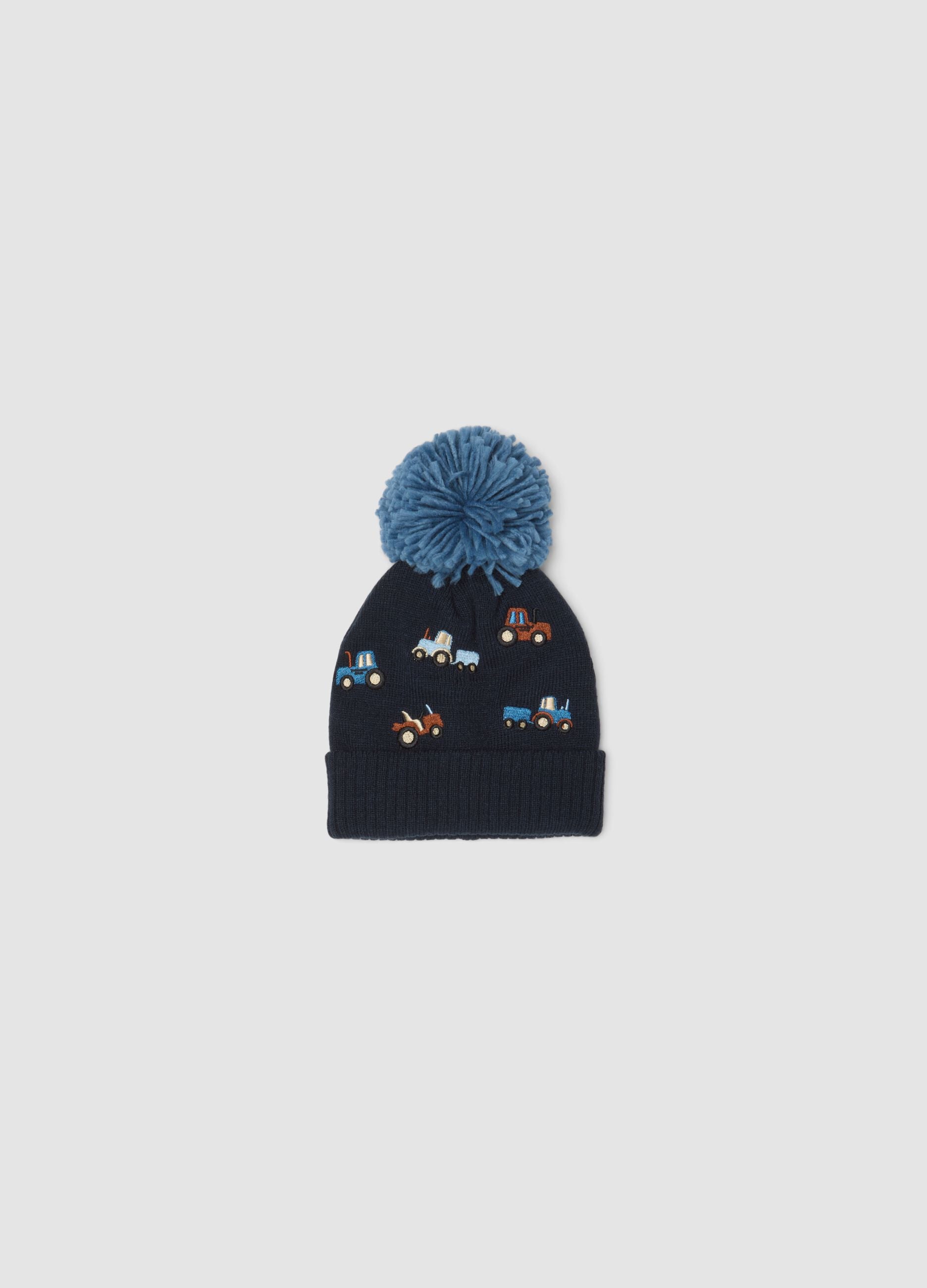 Blue knitted hat with pompom and tractor embroidery