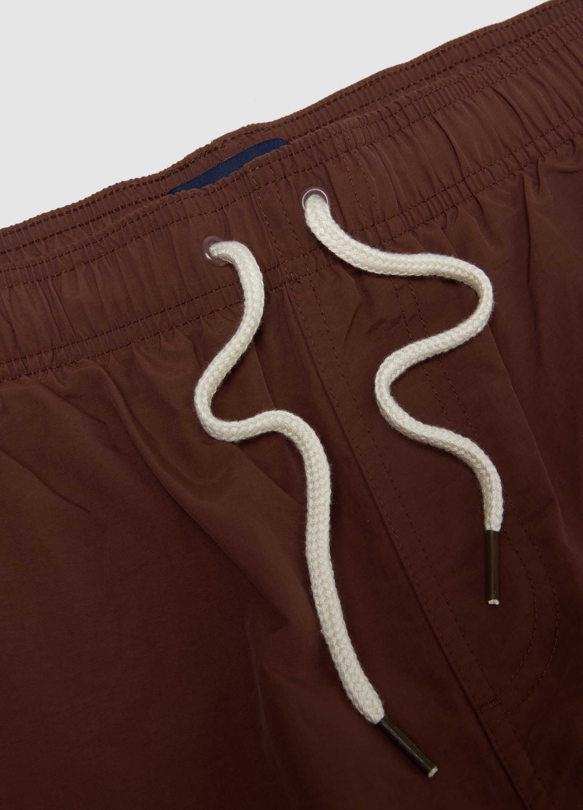 Brown swim shorts with elasticated waistband and drawstring