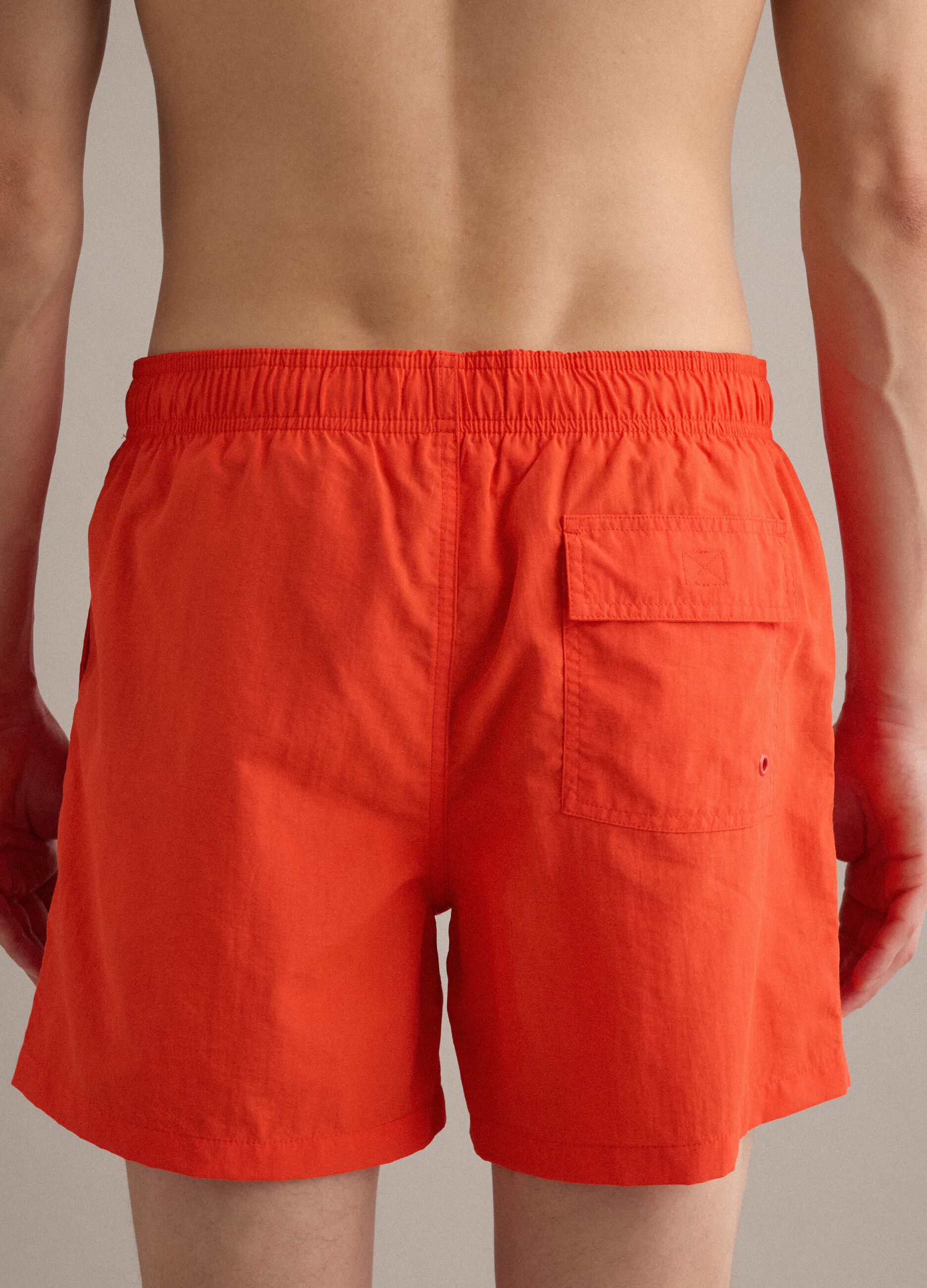 Orange swim shorts with elasticated waistband and drawstring
