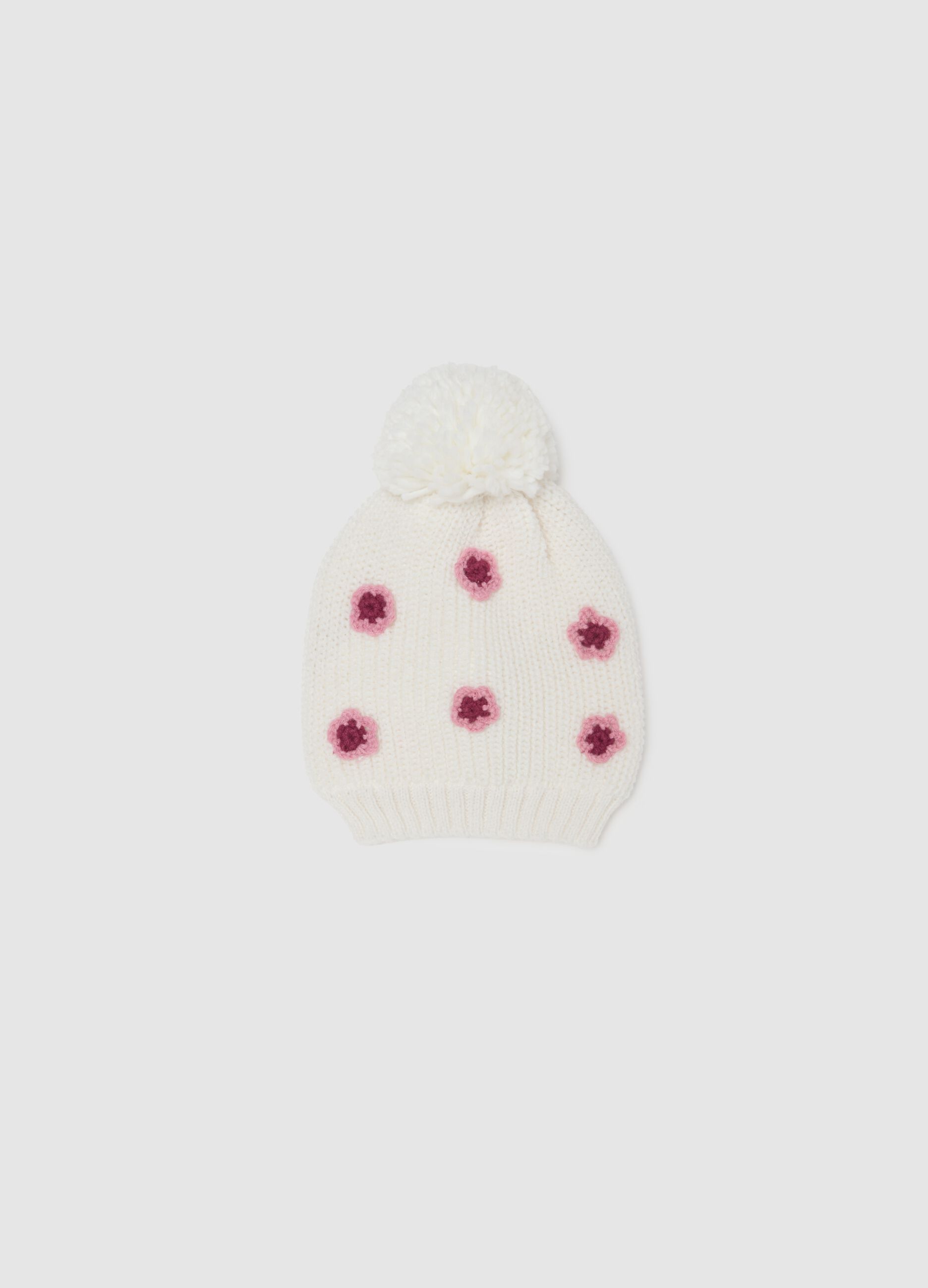 Cappello bianco con pon pon e decorazioni in maglia