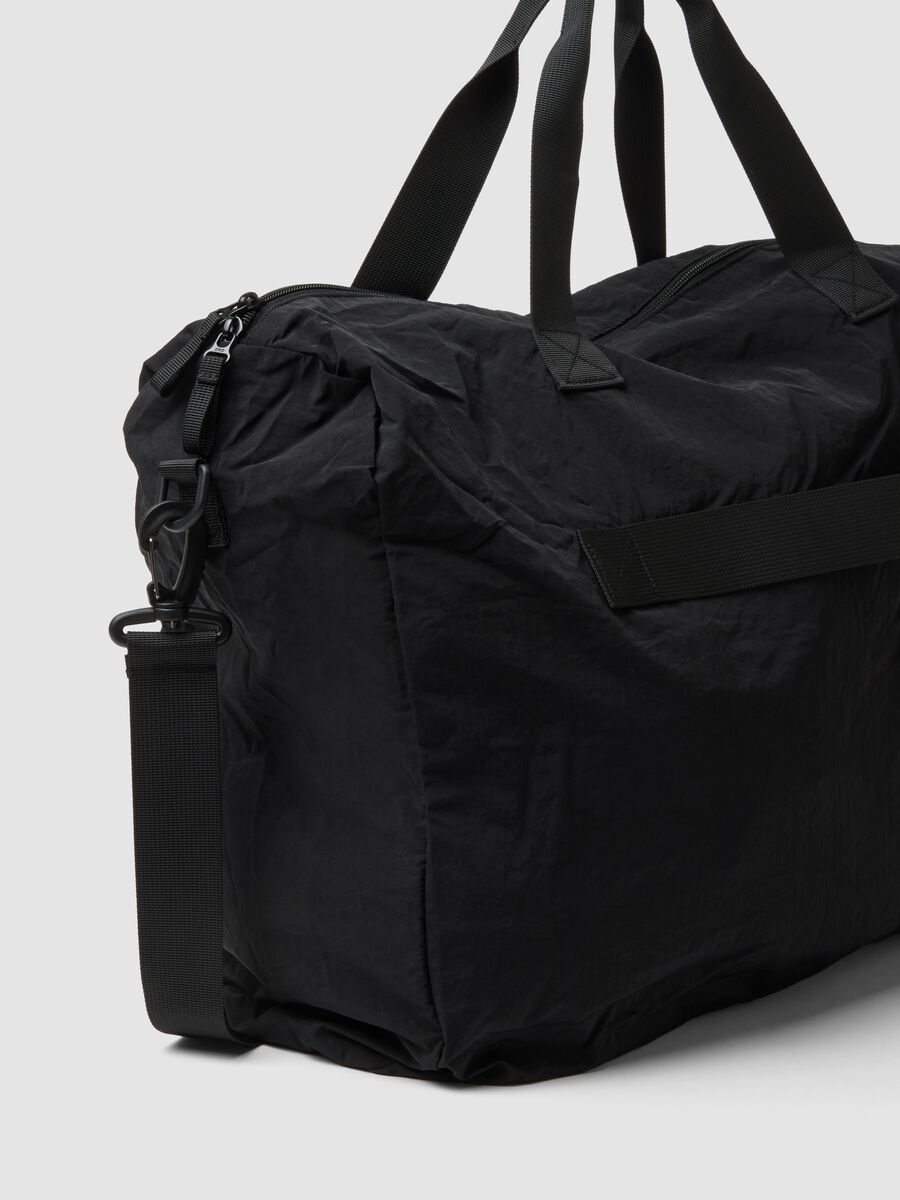 Black foldable travel bag with shoulder strap and zipped pockets_2