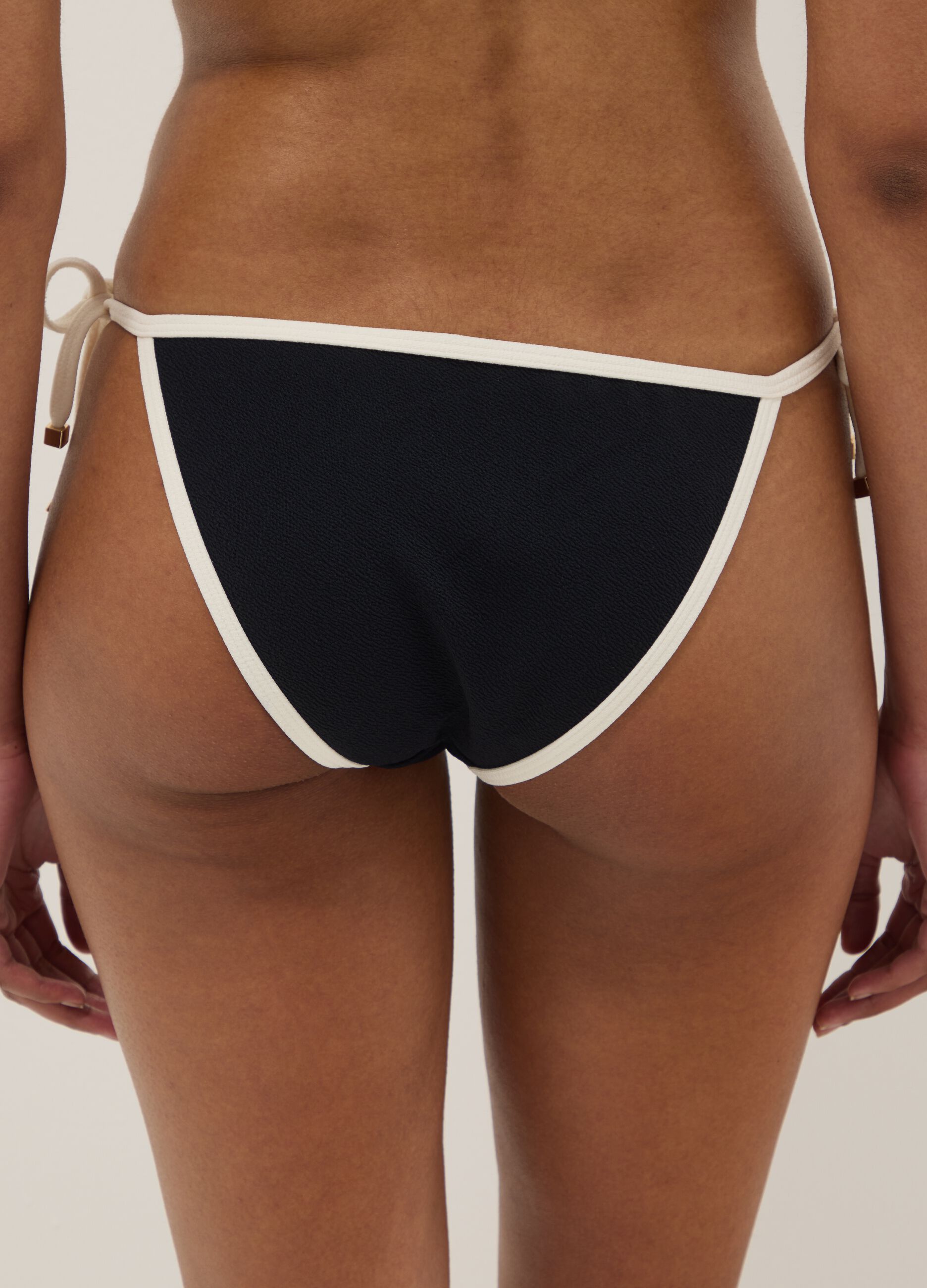 Black and white bikini bottoms in stretch fabric with side ties