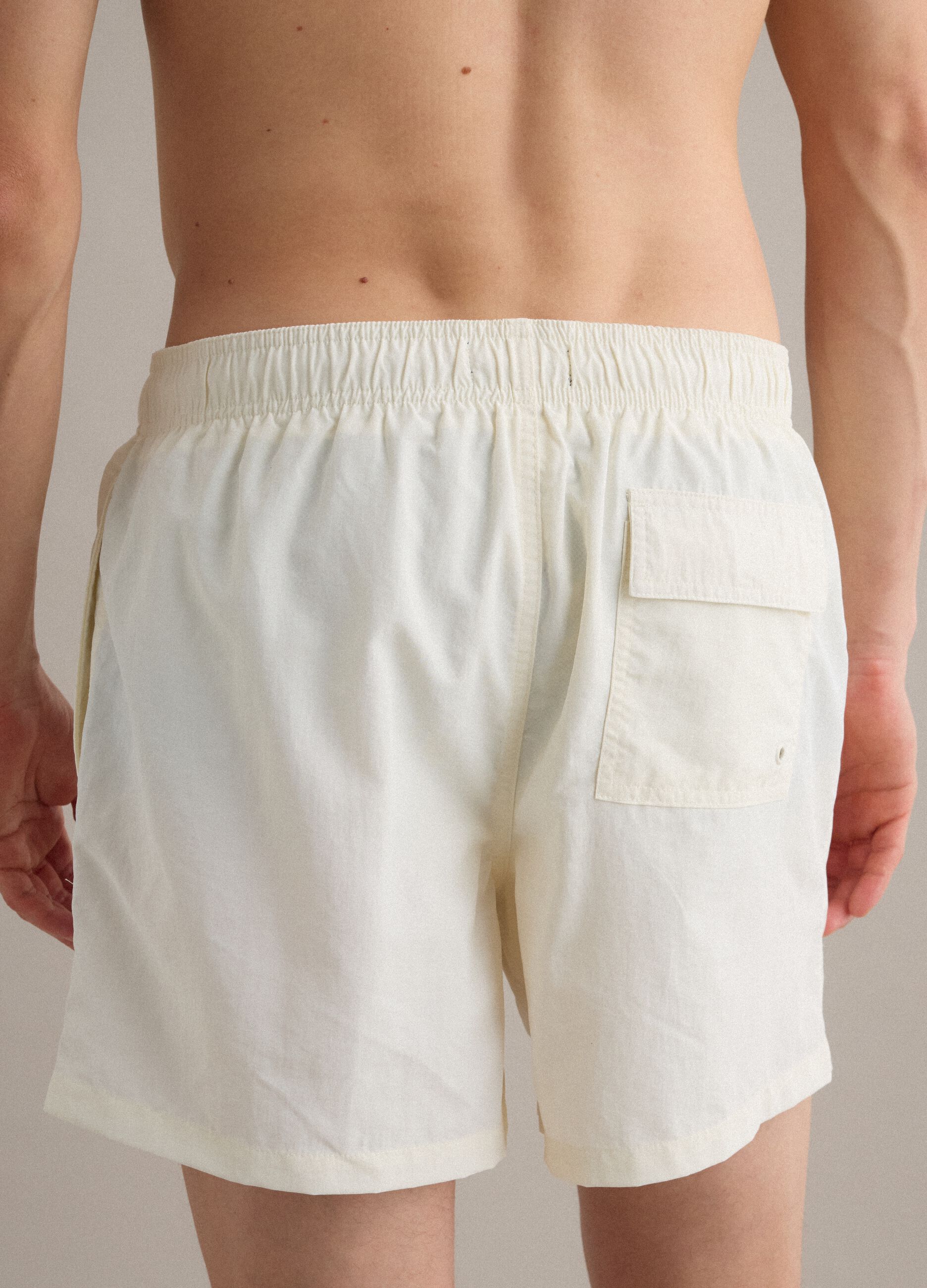 White swim shorts with elasticated waistband and drawstring
