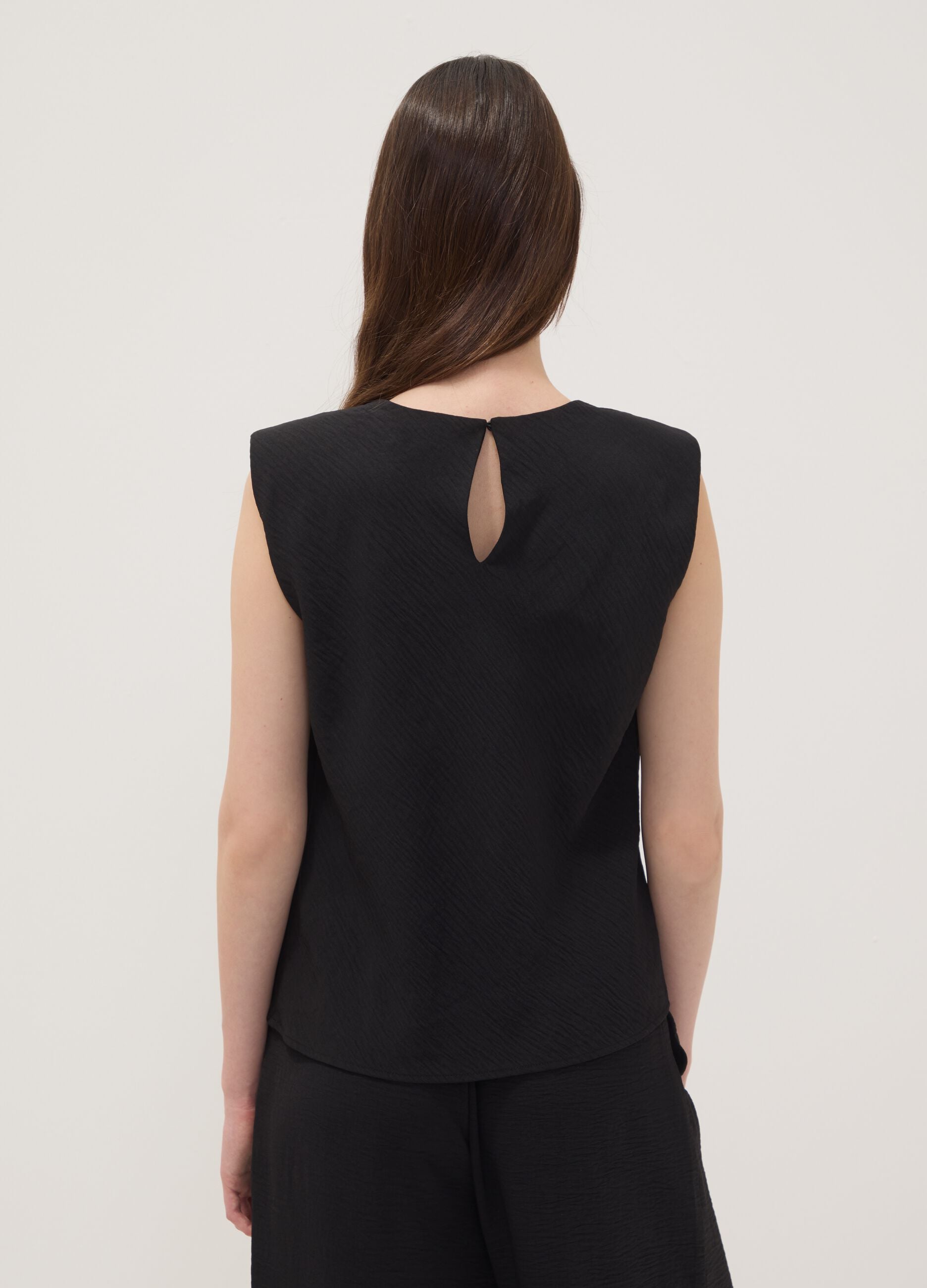 Blusa nera smanicata con texture pliss&eacute; regular fit