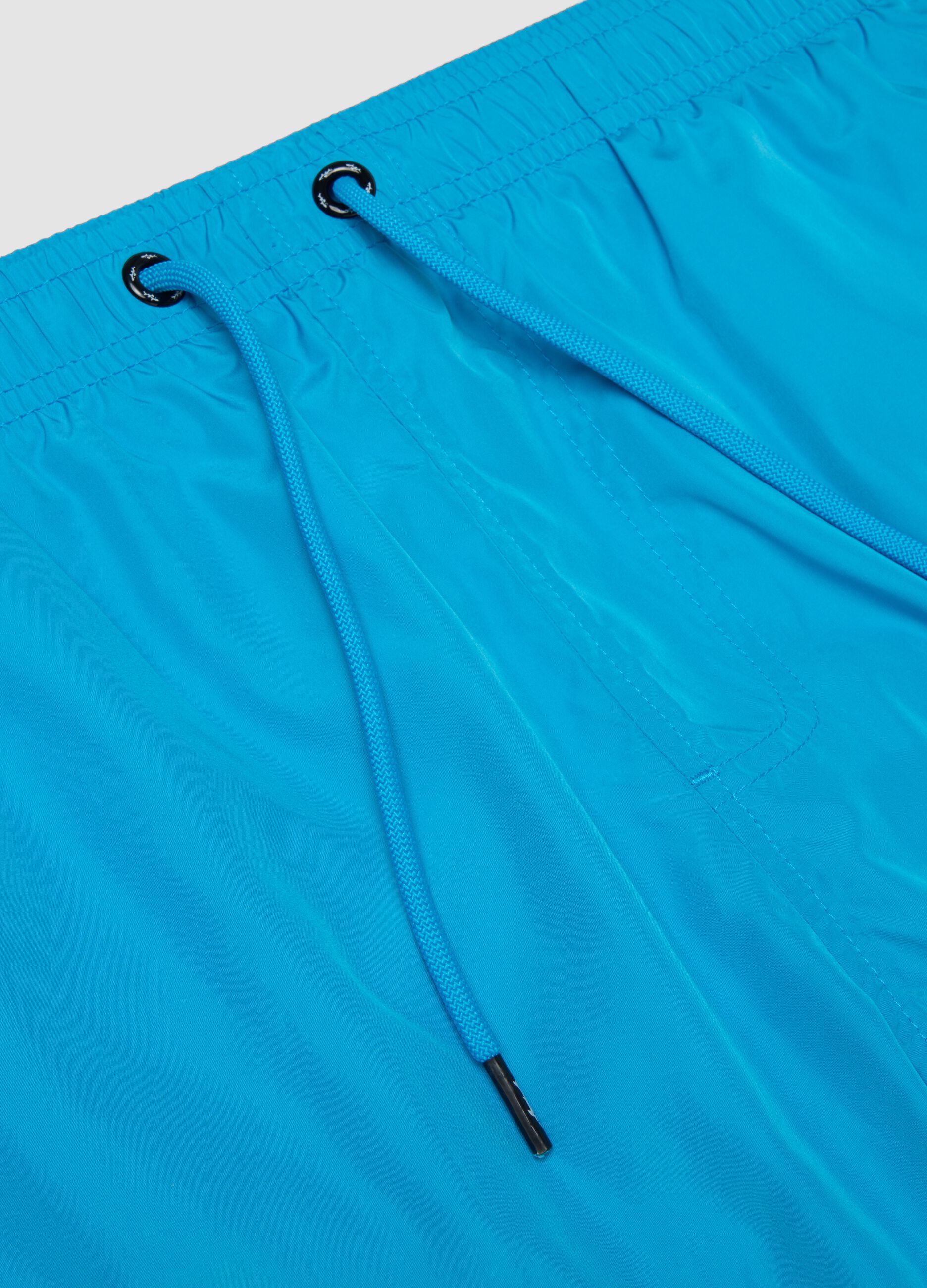 Blue swim shorts with elasticated waist and drawstring