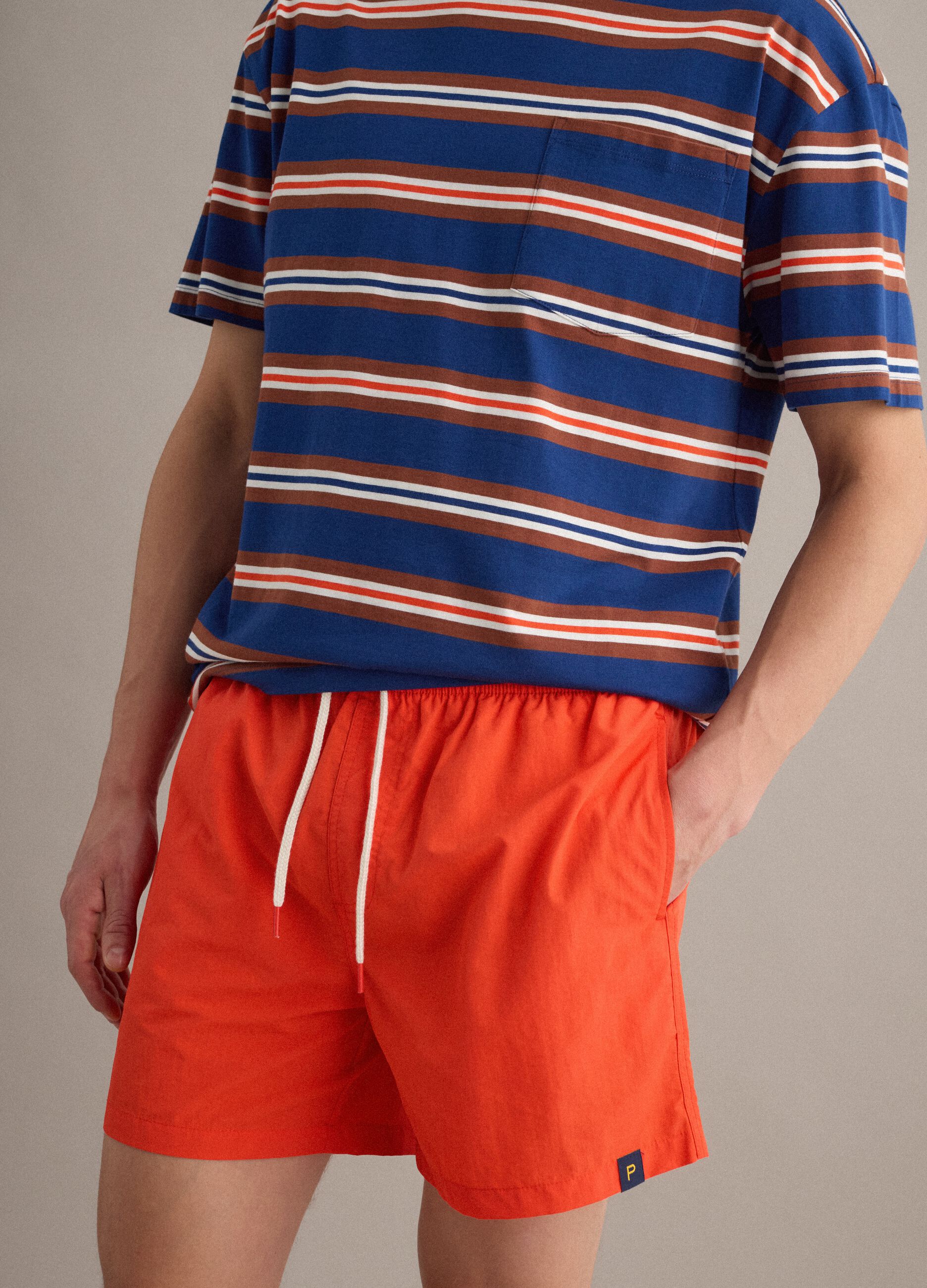 Orange swim shorts with elasticated waistband and drawstring