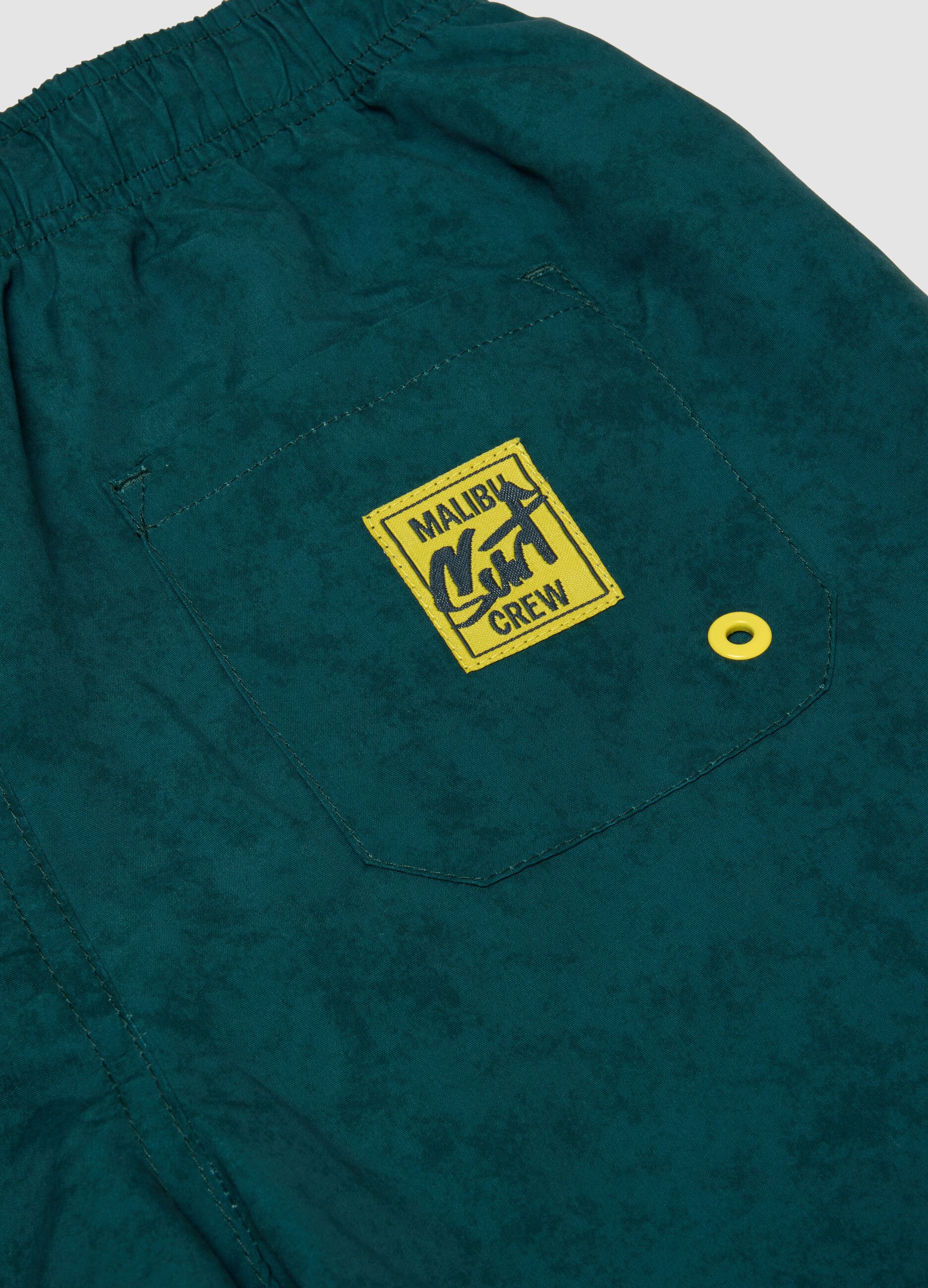 Green swim shorts with graphic print