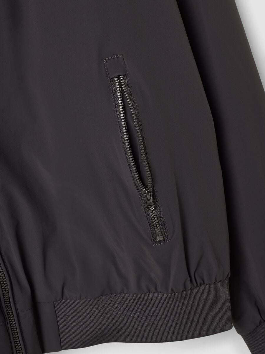 Giubbotto nero in tessuto elasticizzato con zip_1