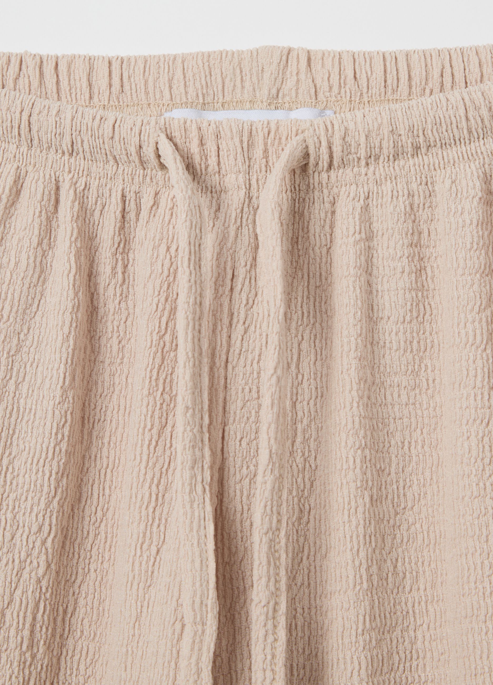 Women's beige regular-fit palazzo pants in stretch fabric.