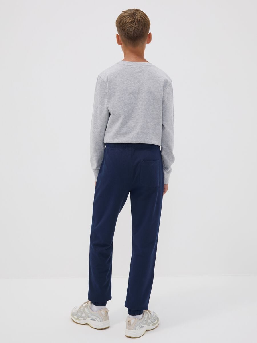 Jogger blu in puro cotone con stampa college per ragazzo_1