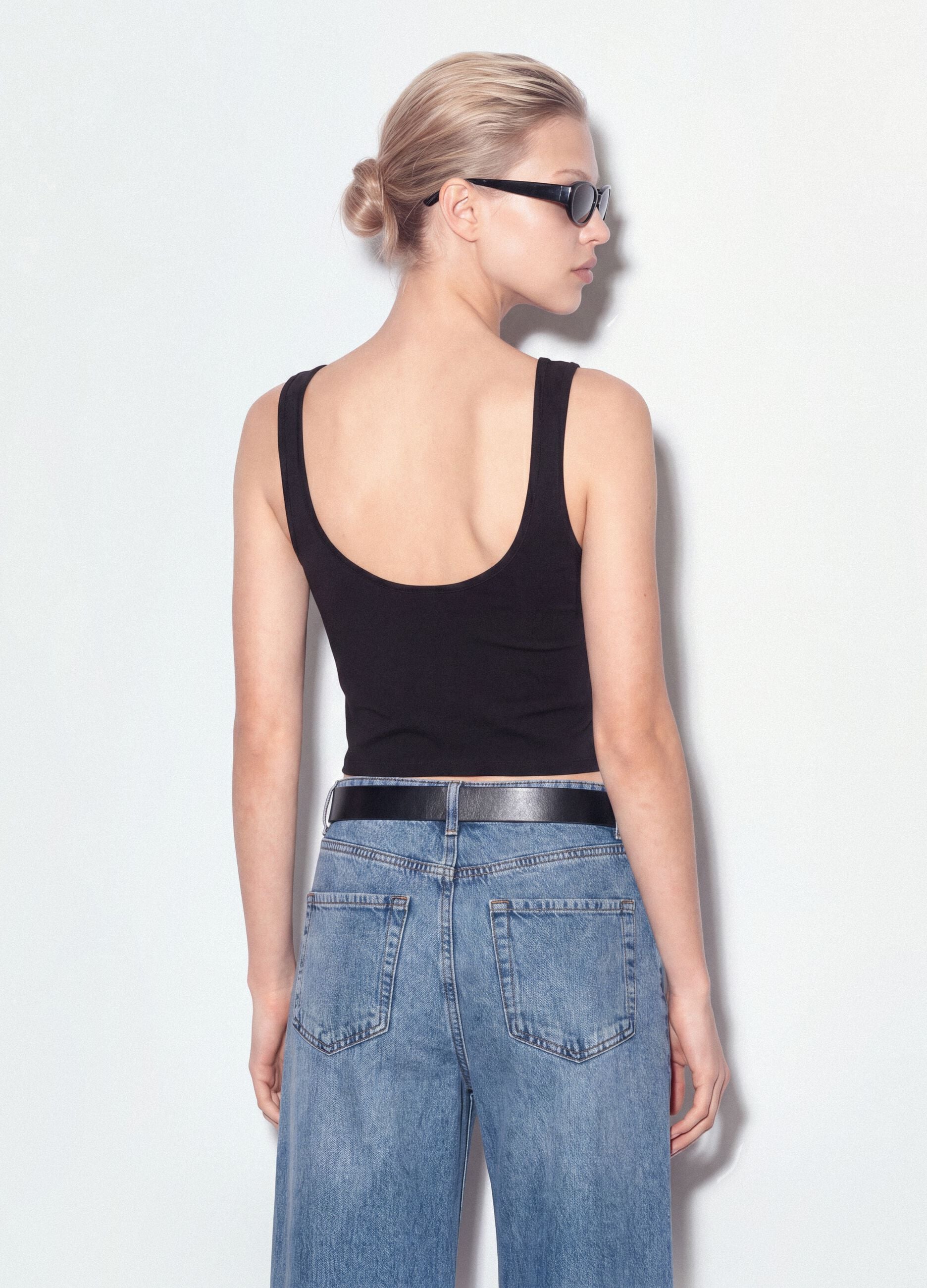 Black stretch cotton top with asymmetric hem and metal eyelets