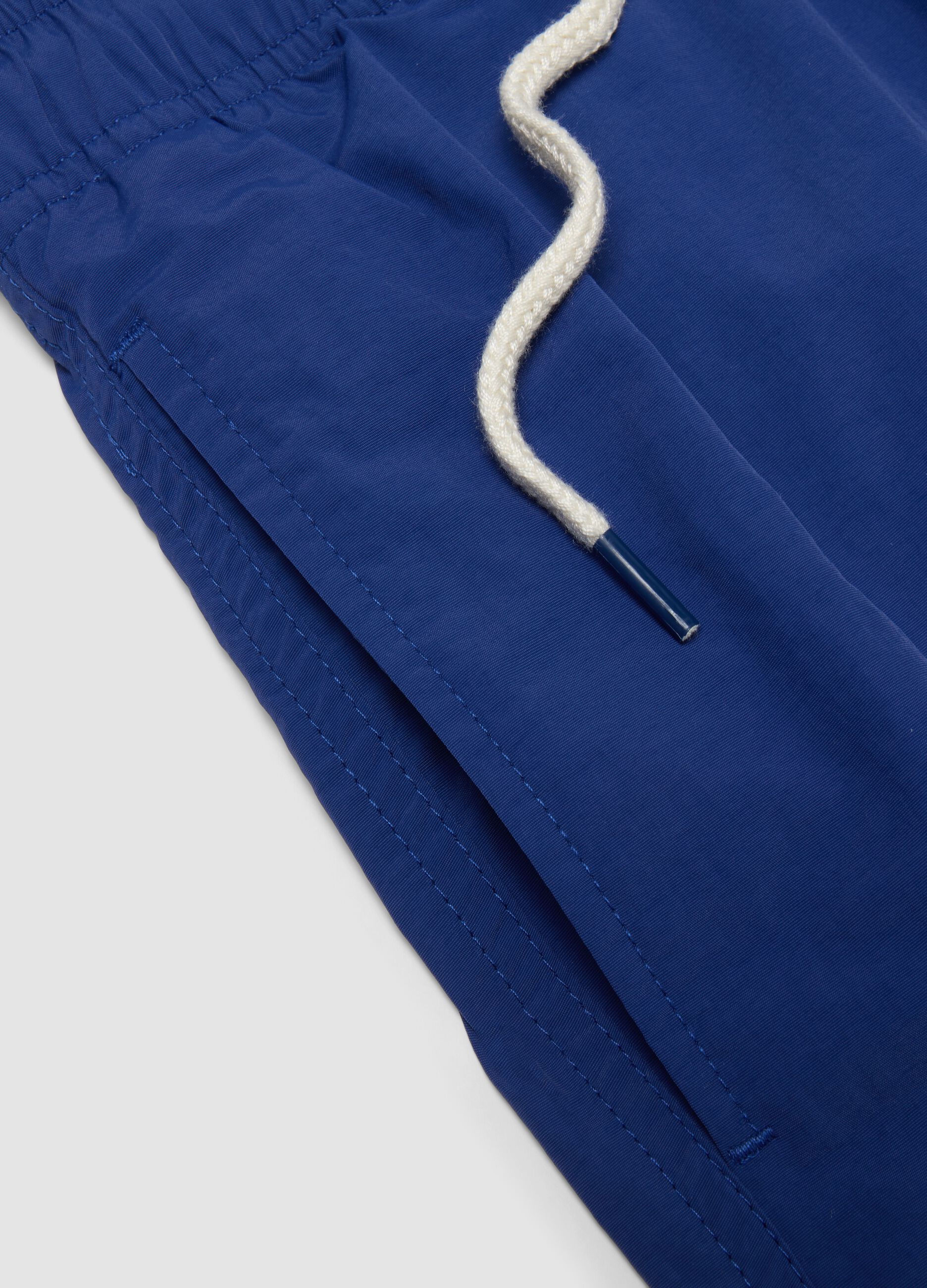 Blue swim shorts with elasticated waist and drawstring