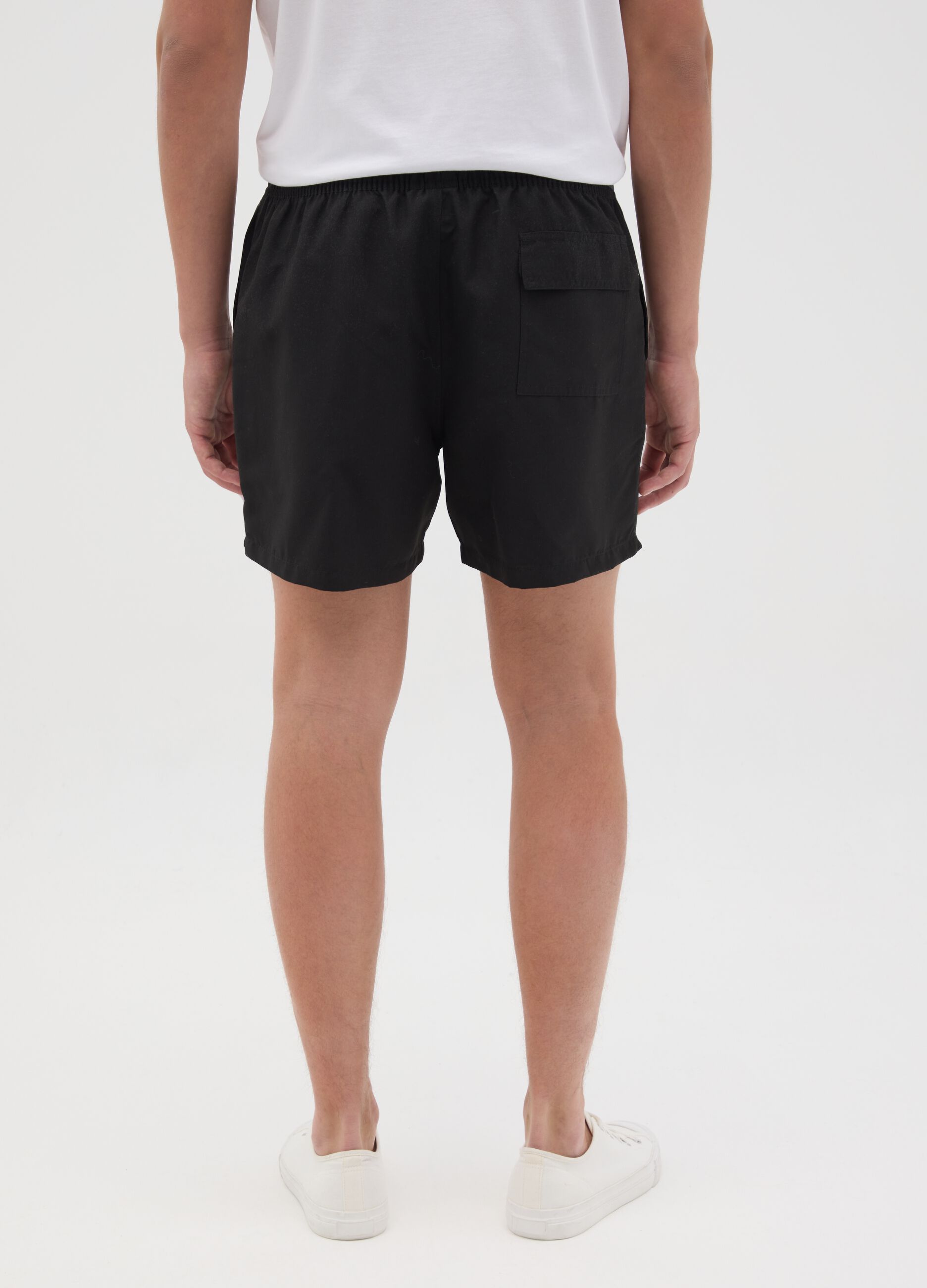Black swimming trunks with logo print