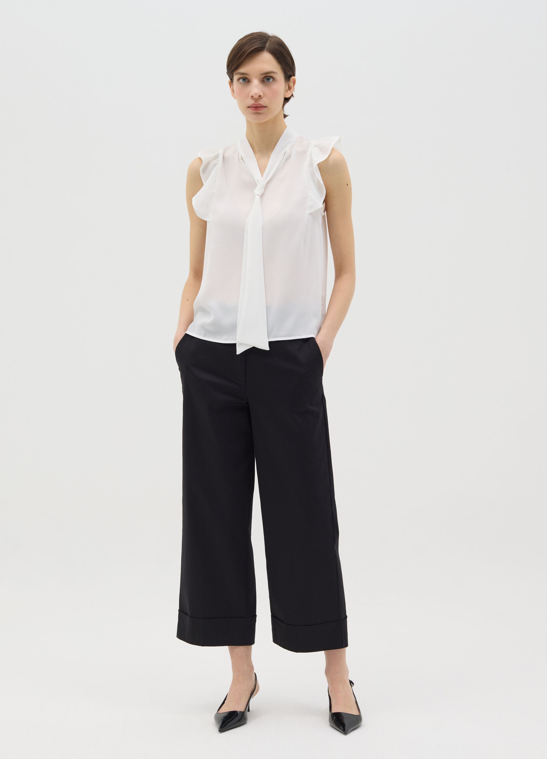 White sleeveless blouse with flounce