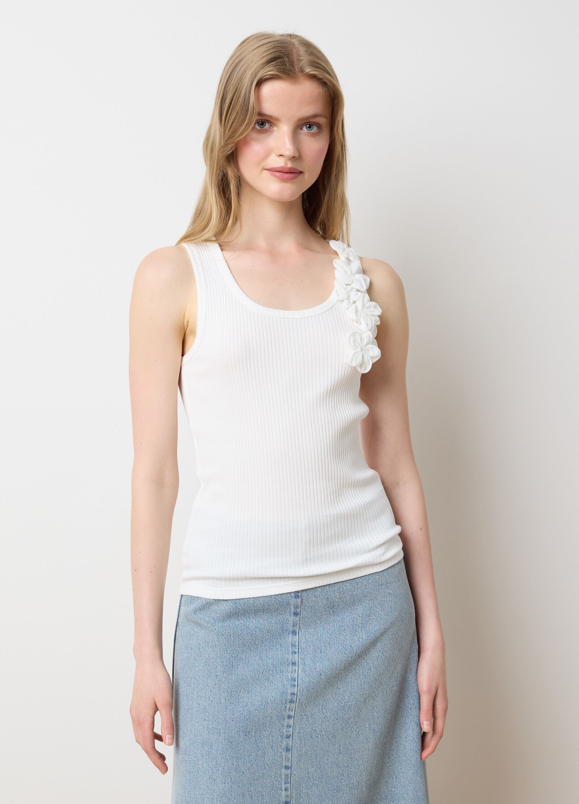 Top bianco a costine con applicazioni floreali