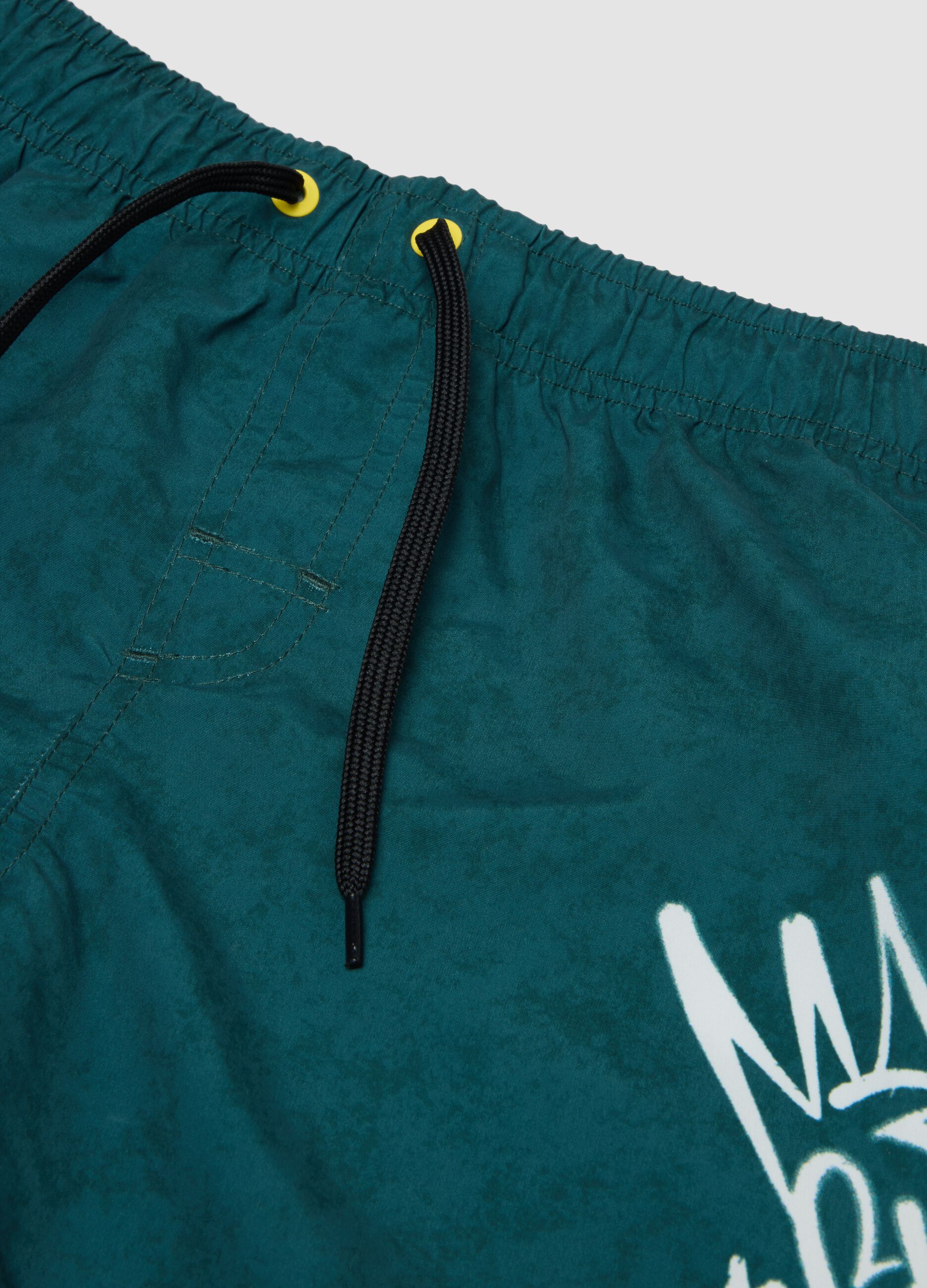 Green swim shorts with graphic print