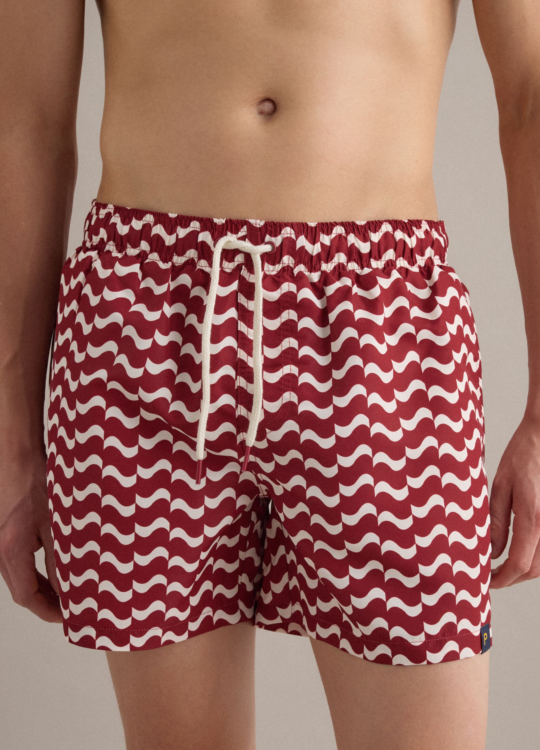 Red men&rsquo;s swim shorts with all-over print