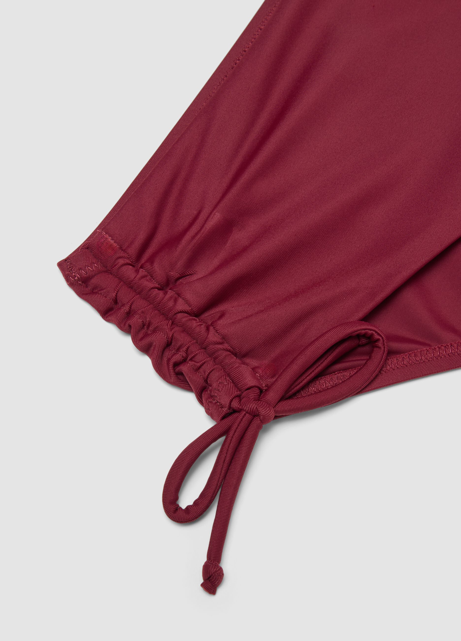 Red stretch bikini bottoms with ruched side detailing