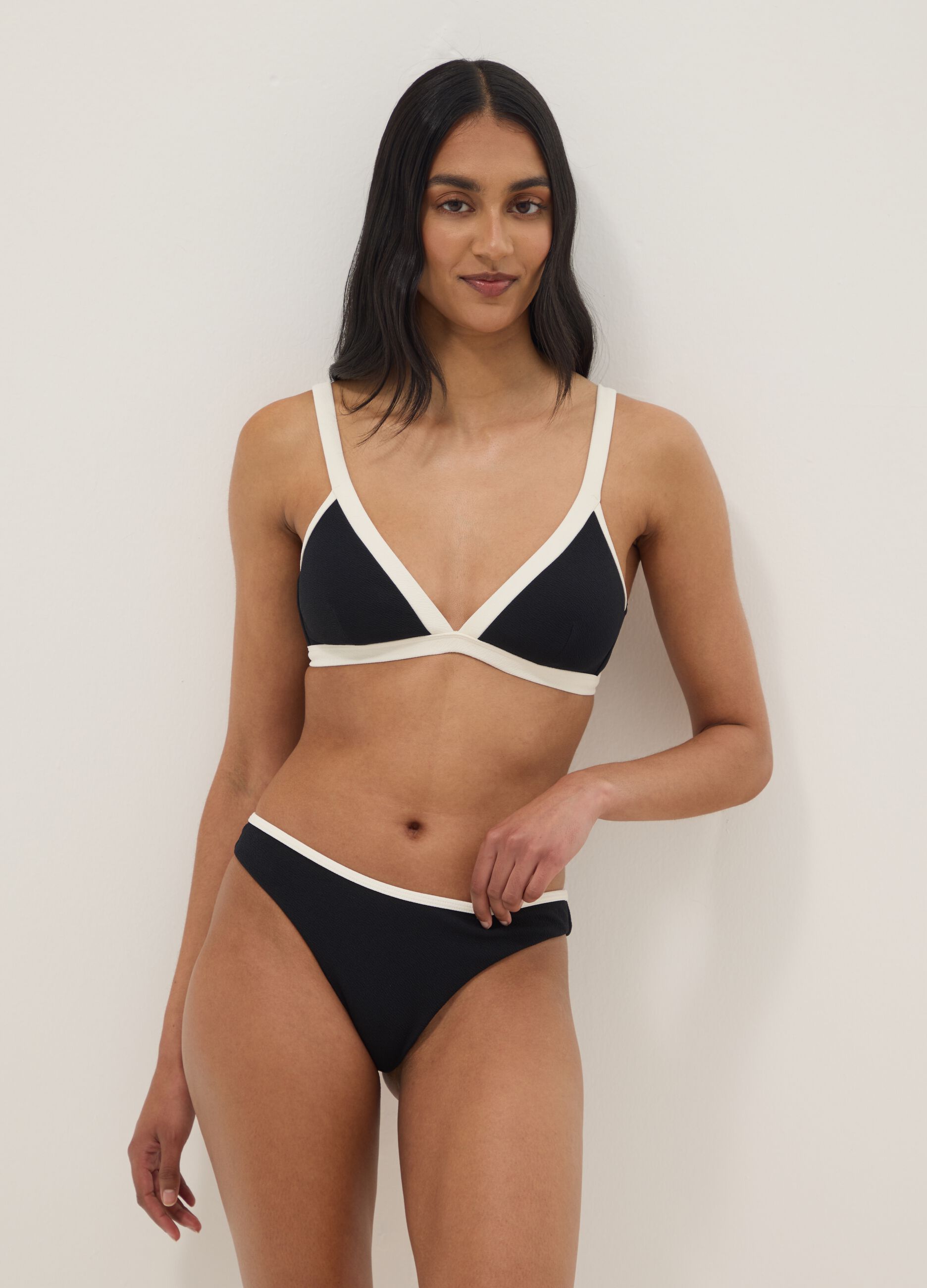 Black stretch-fabric bikini top with white trim and straps