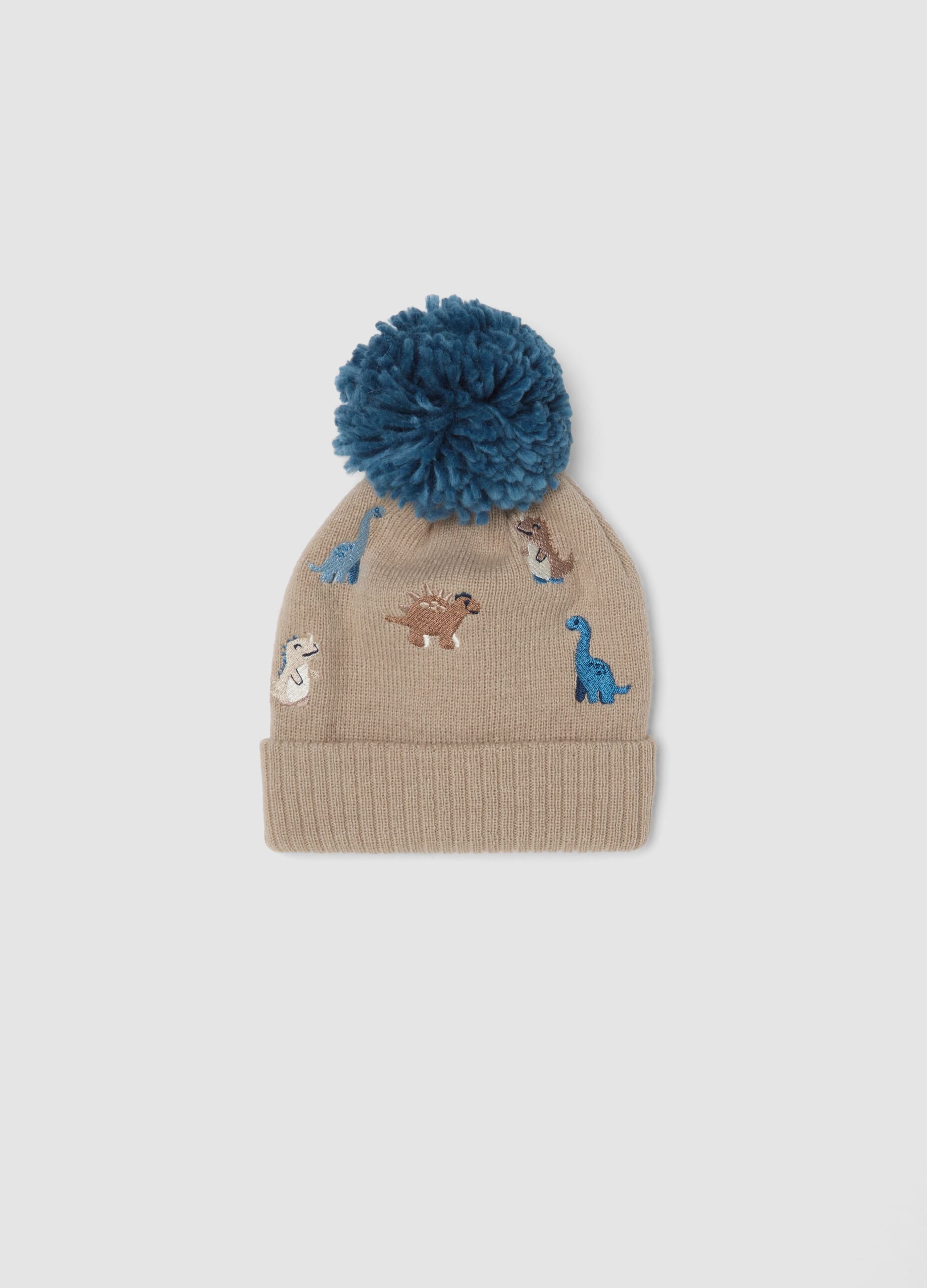 Beige hat with pom‑pom and dinosaurs