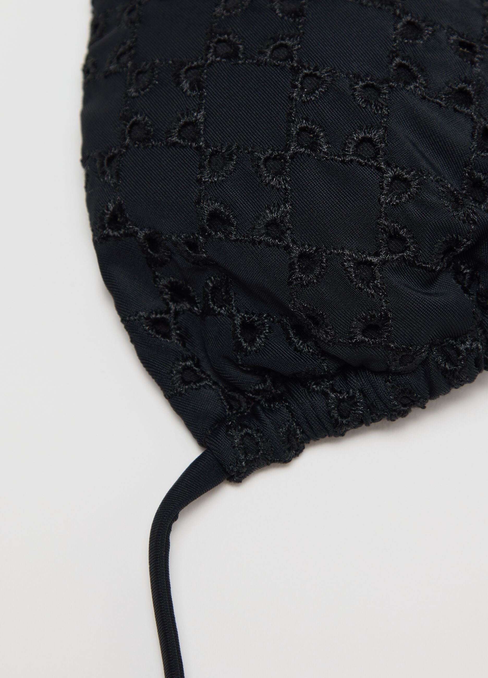 Women’s bikini top in black stretch fabric with perforated design.