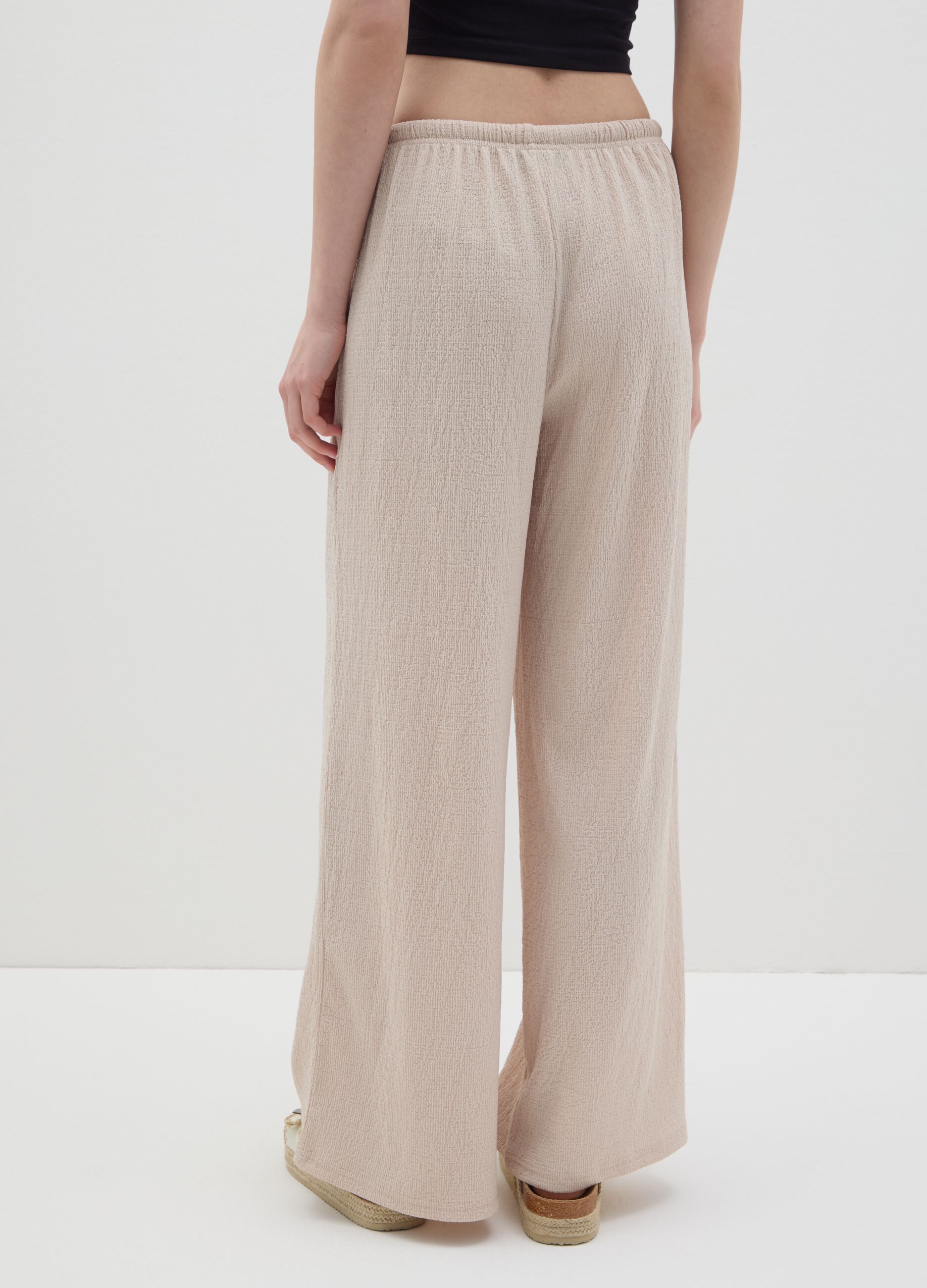 Women's beige regular-fit palazzo pants in stretch fabric.