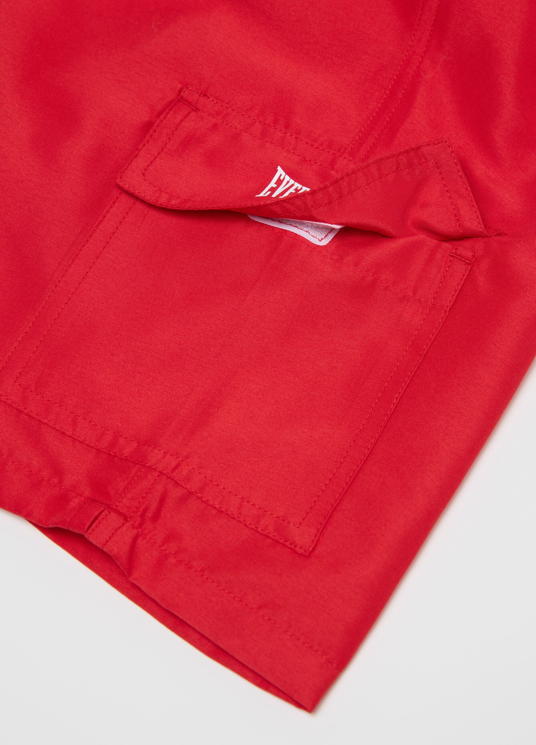 Red swimming trunks with logo print