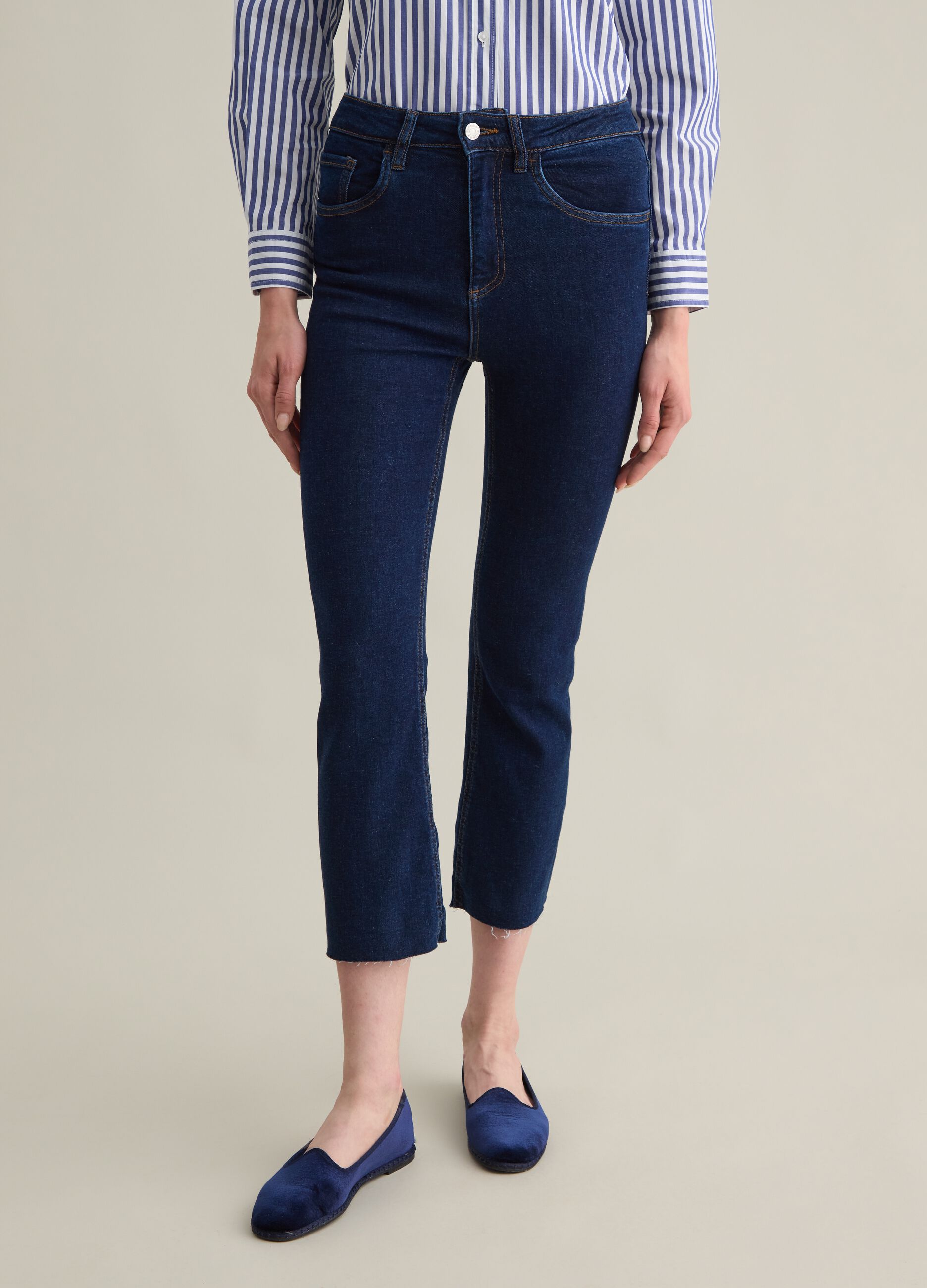 Cropped blue flare-fit jeans with raw edging