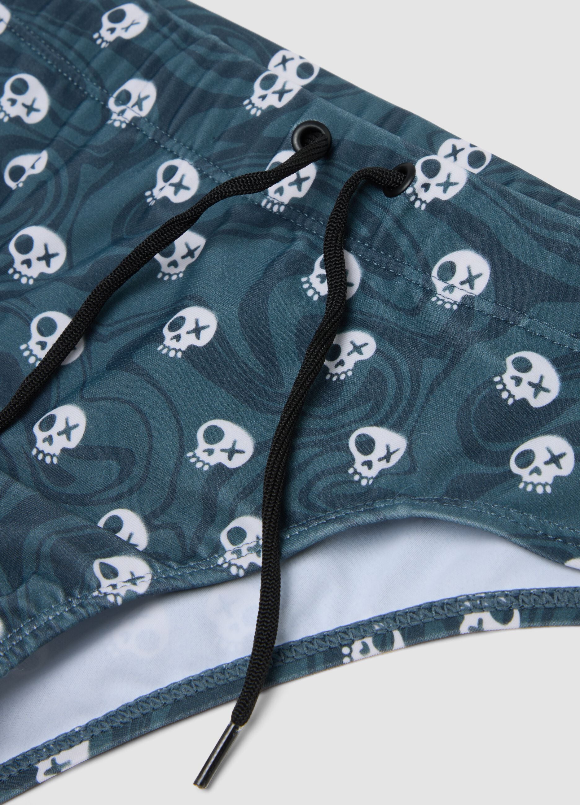 Blue stretch swim briefs with skull print
