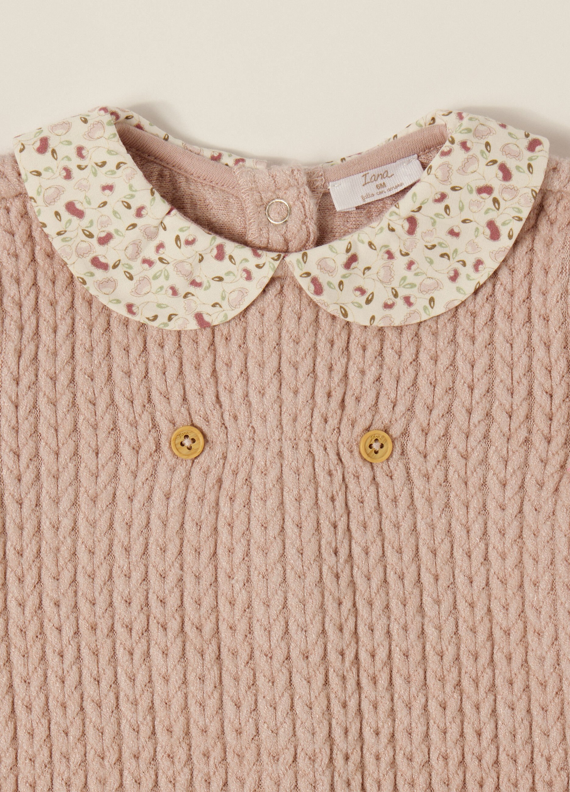 Pink knitted baby romper with floral collar