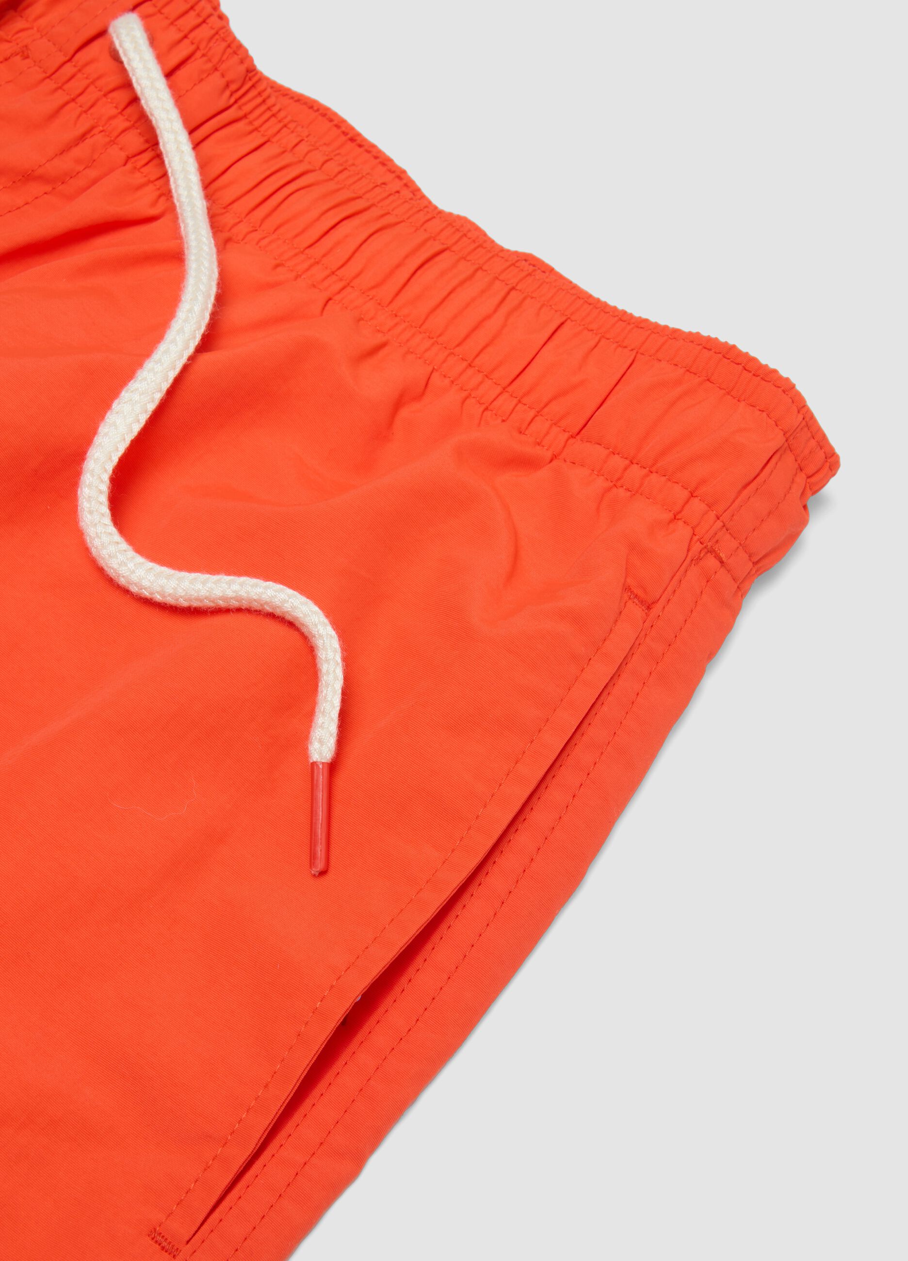 Orange swim shorts with elasticated waistband and drawstring