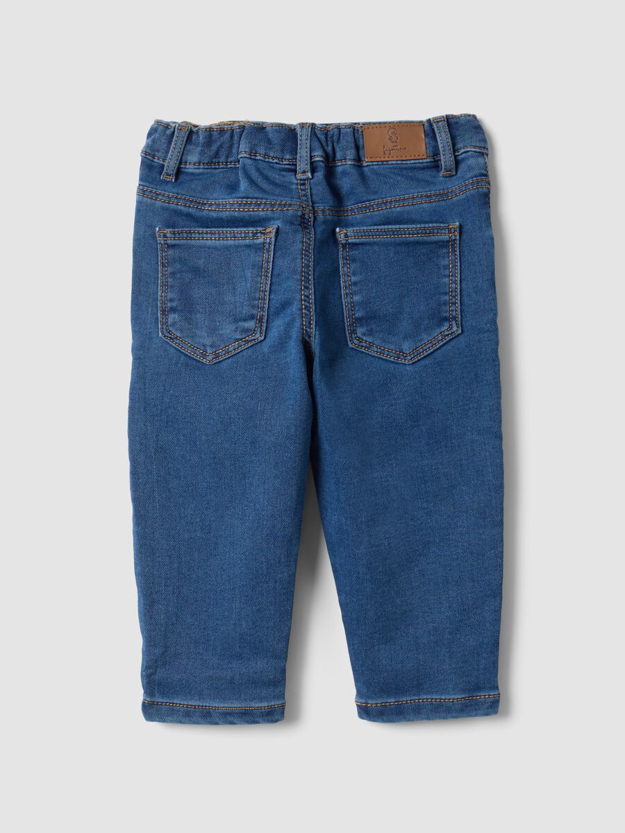 Jeans blu in cotone elasticizzato con applicazioni college per bimbo_1