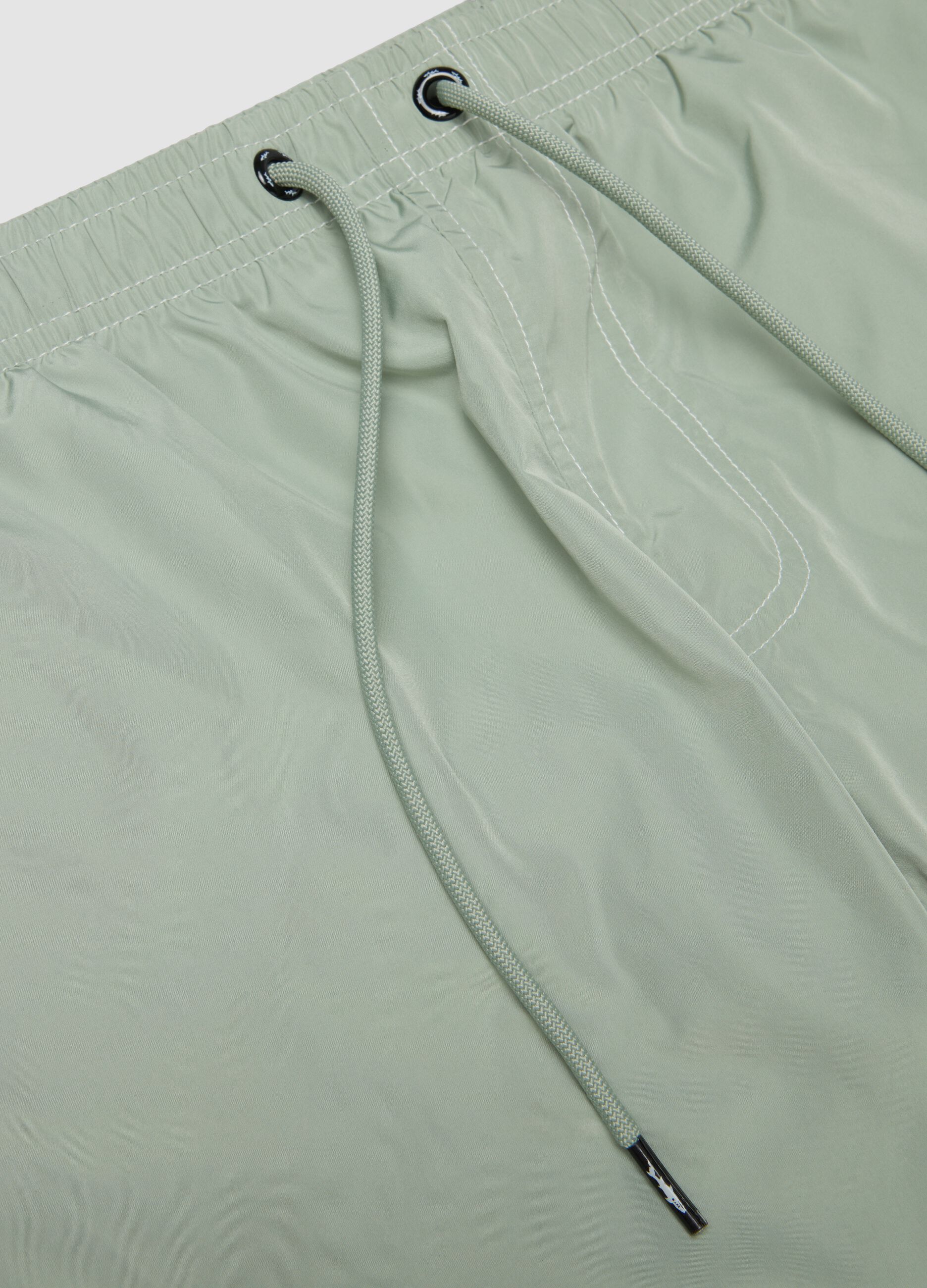 Green swim shorts with elasticated waistband and drawstring