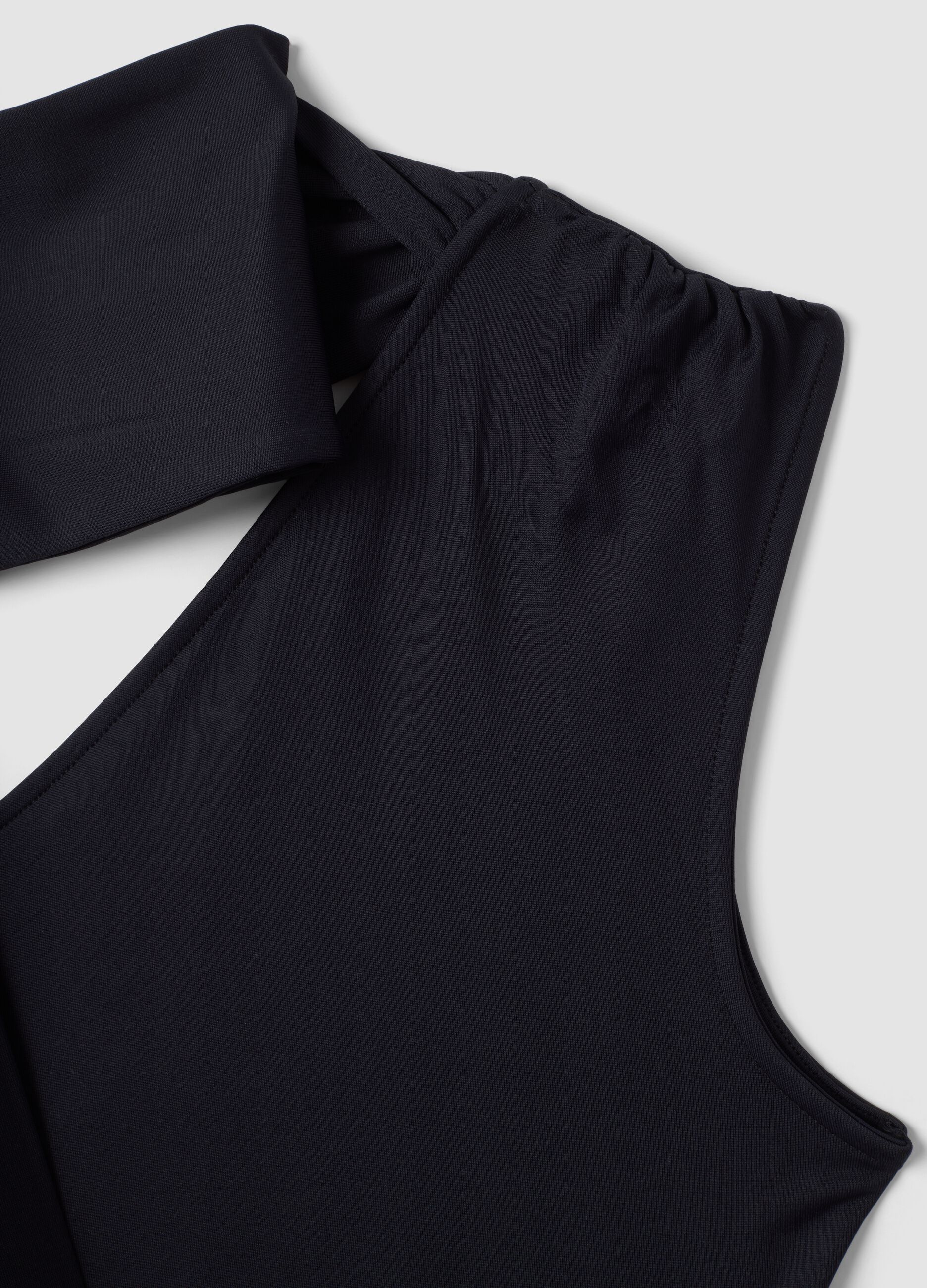 Top nero in tessuto elasticizzato con scollo asimmetrico e fascia drappeggiata