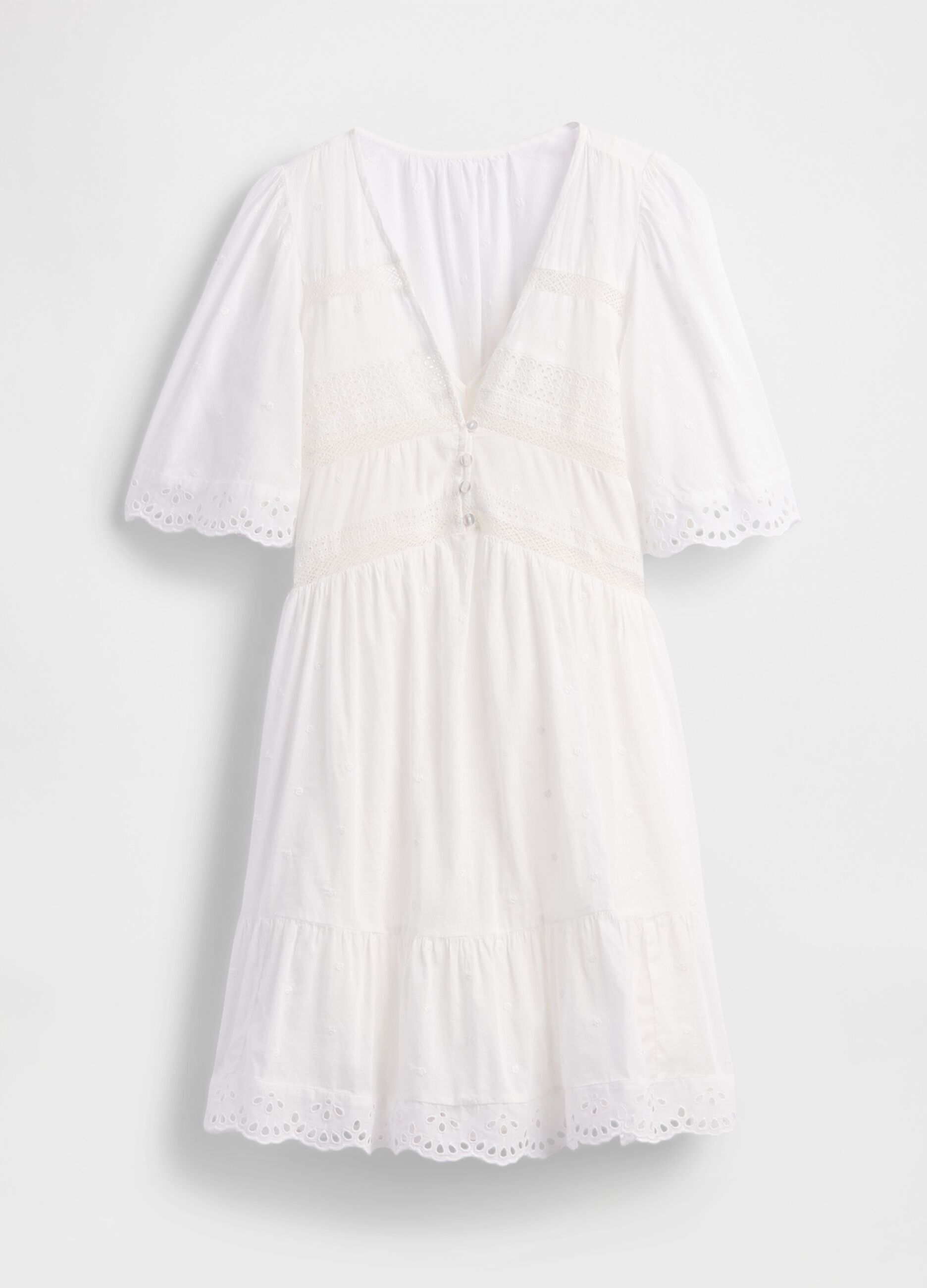 Short white dress in embroidered fabric