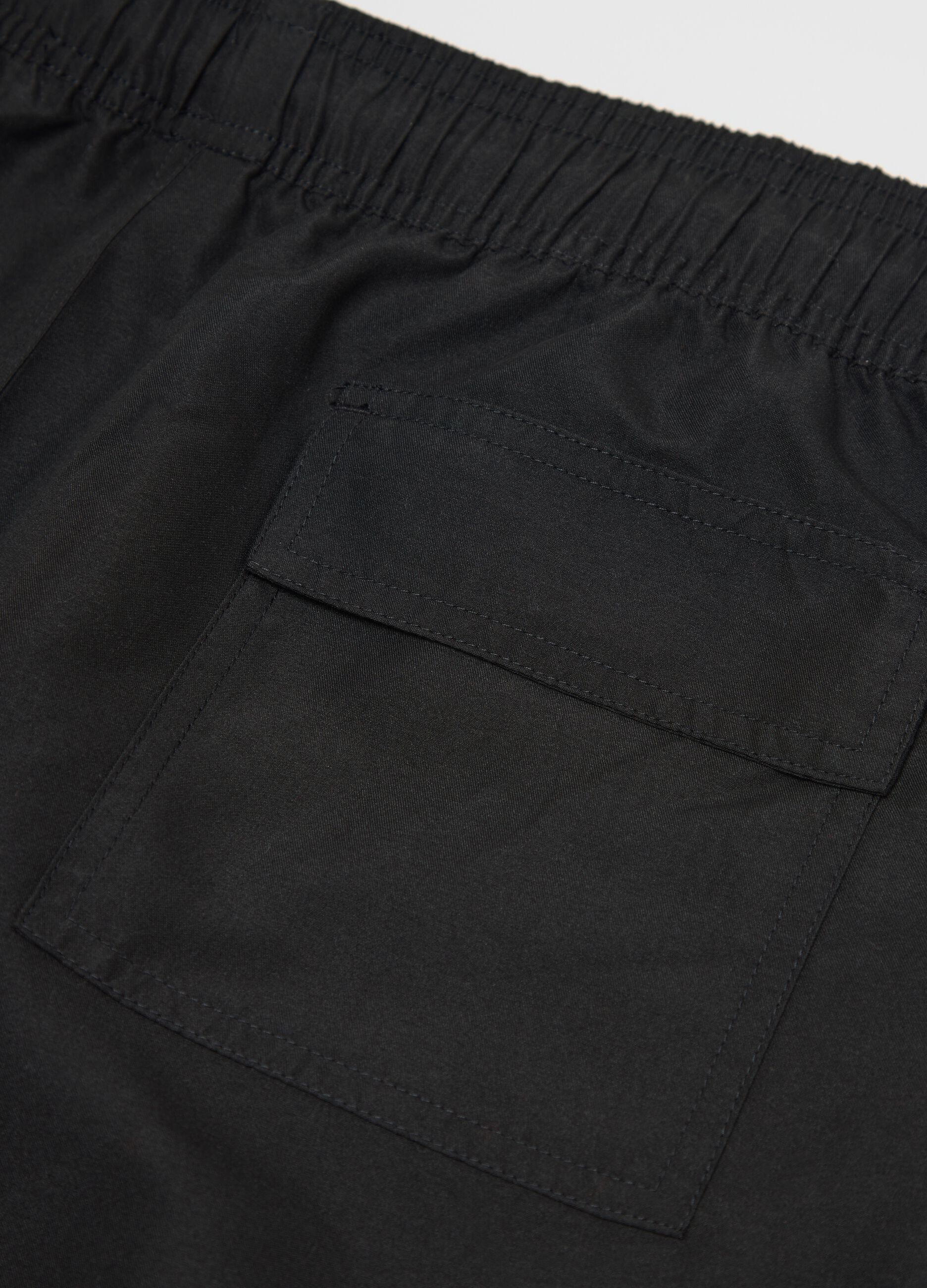 Black swimming trunks with logo print