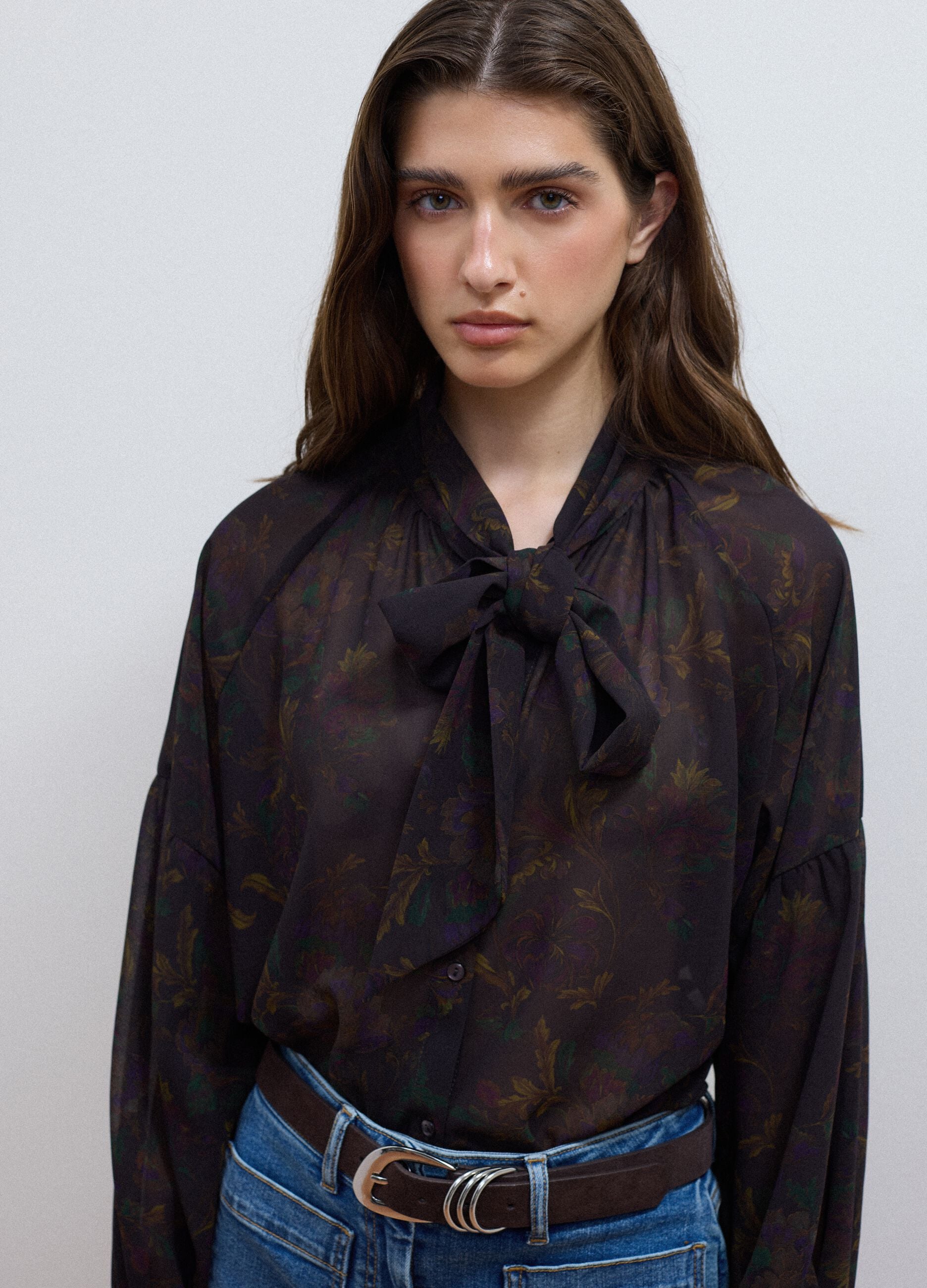 Camicia nera con fantasia floreale e fiocco al collo