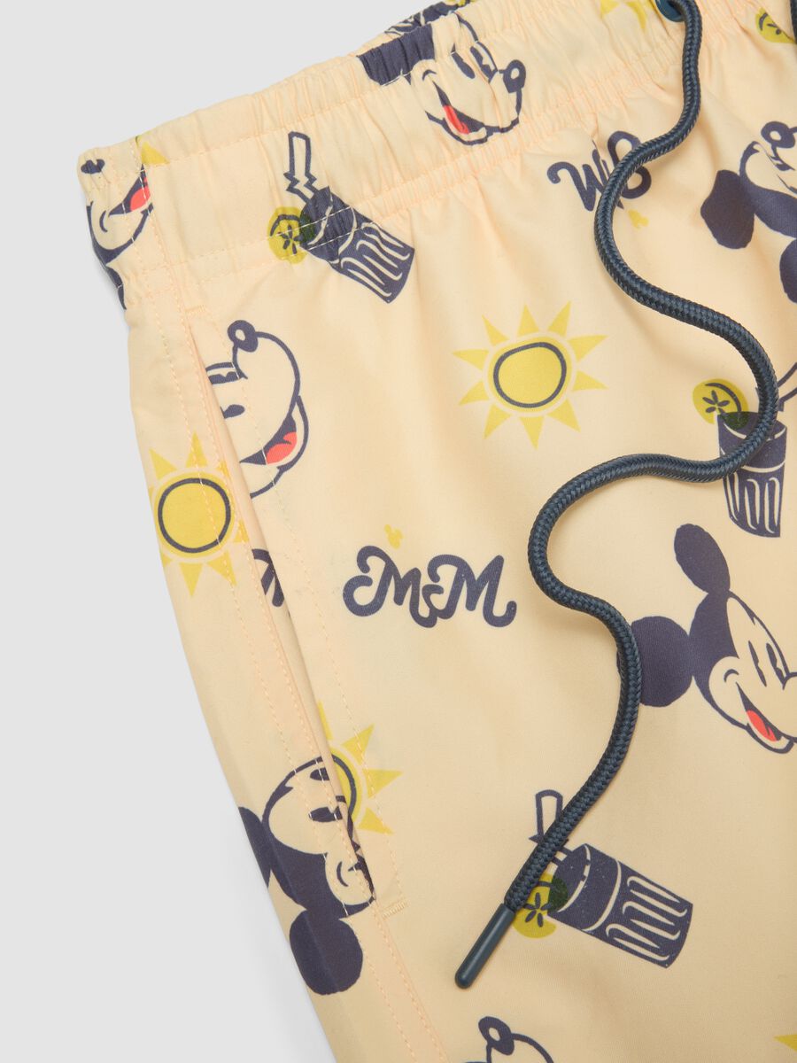 Orange swim trunks with Mickey Mouse prints_1