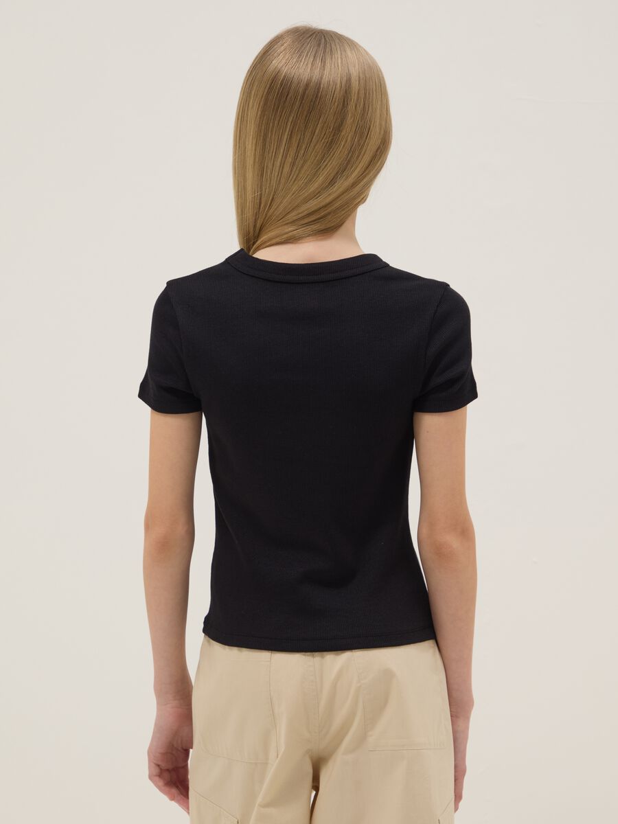 T-shirt fitted in cotone elasticizzato nera da ragazza con frase_1
