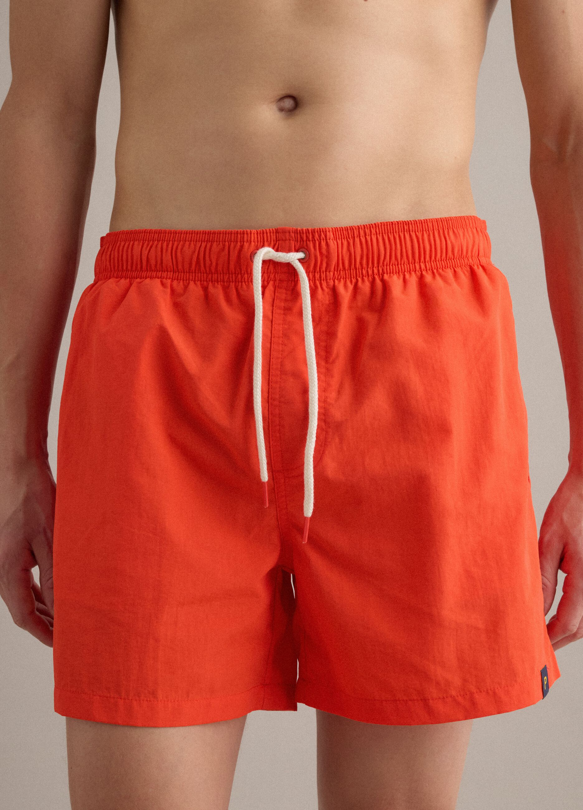 Orange swim shorts with elasticated waistband and drawstring