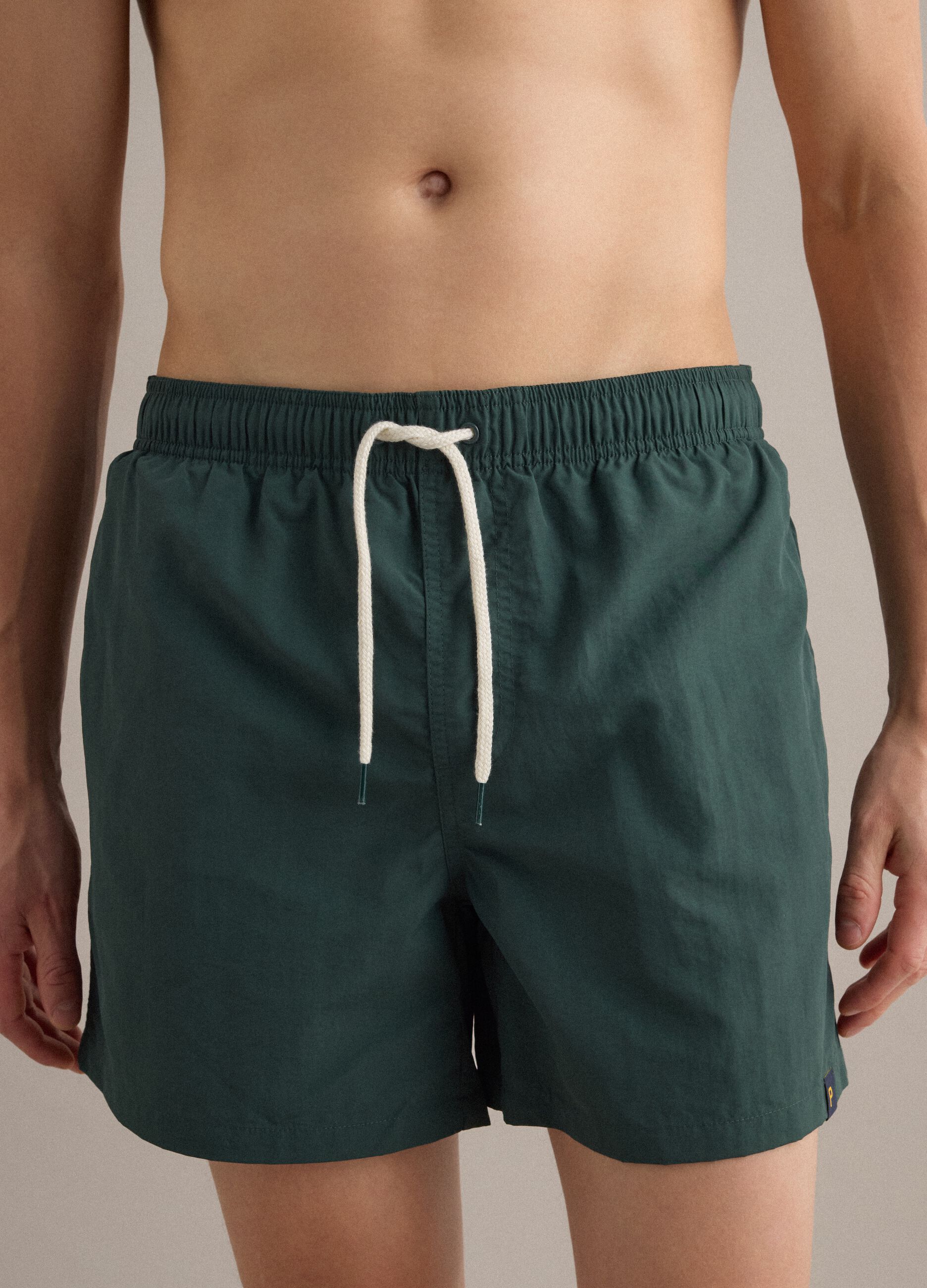 Green swim shorts with elasticated waistband and drawstring