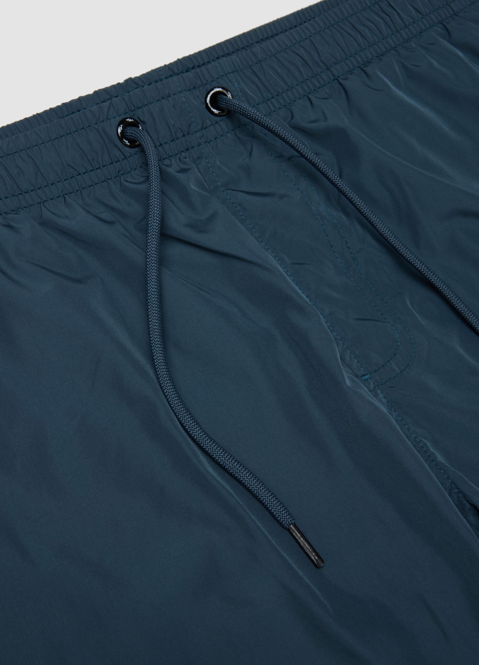 Blue swim shorts with elasticated waistband and drawstring