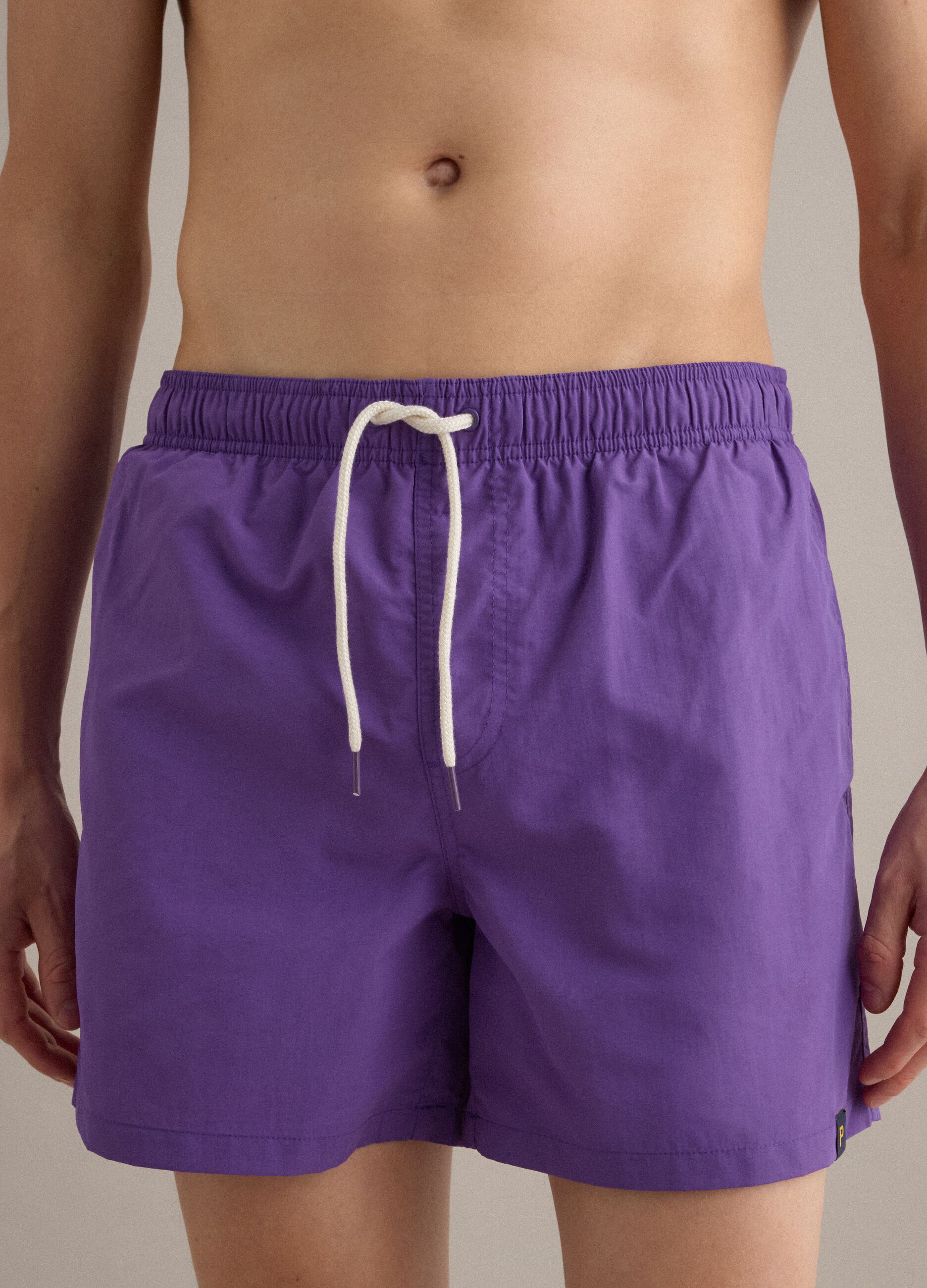 Purple swim shorts with elasticated waistband and drawstring