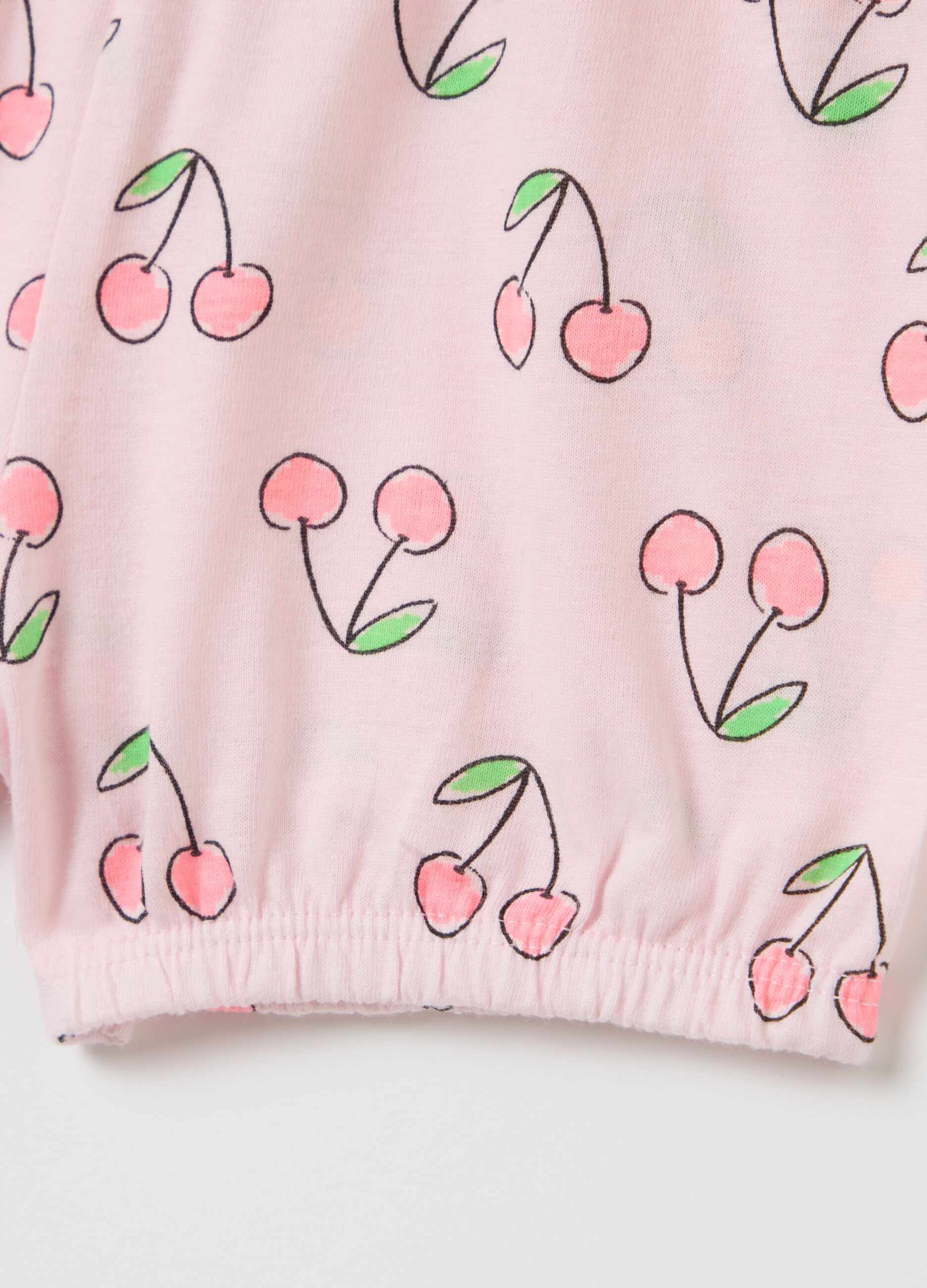 Short pyjama set with white top and cherry-patterned pink shorts