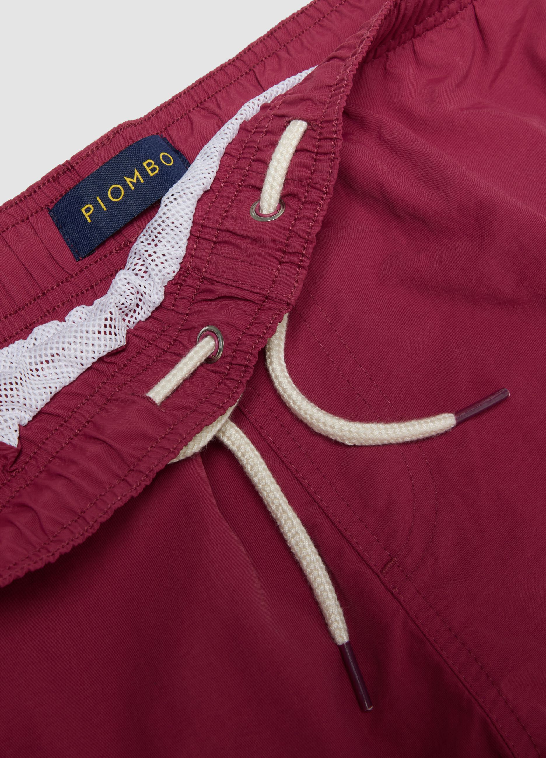Red swim shorts with elasticated waistband and drawstring